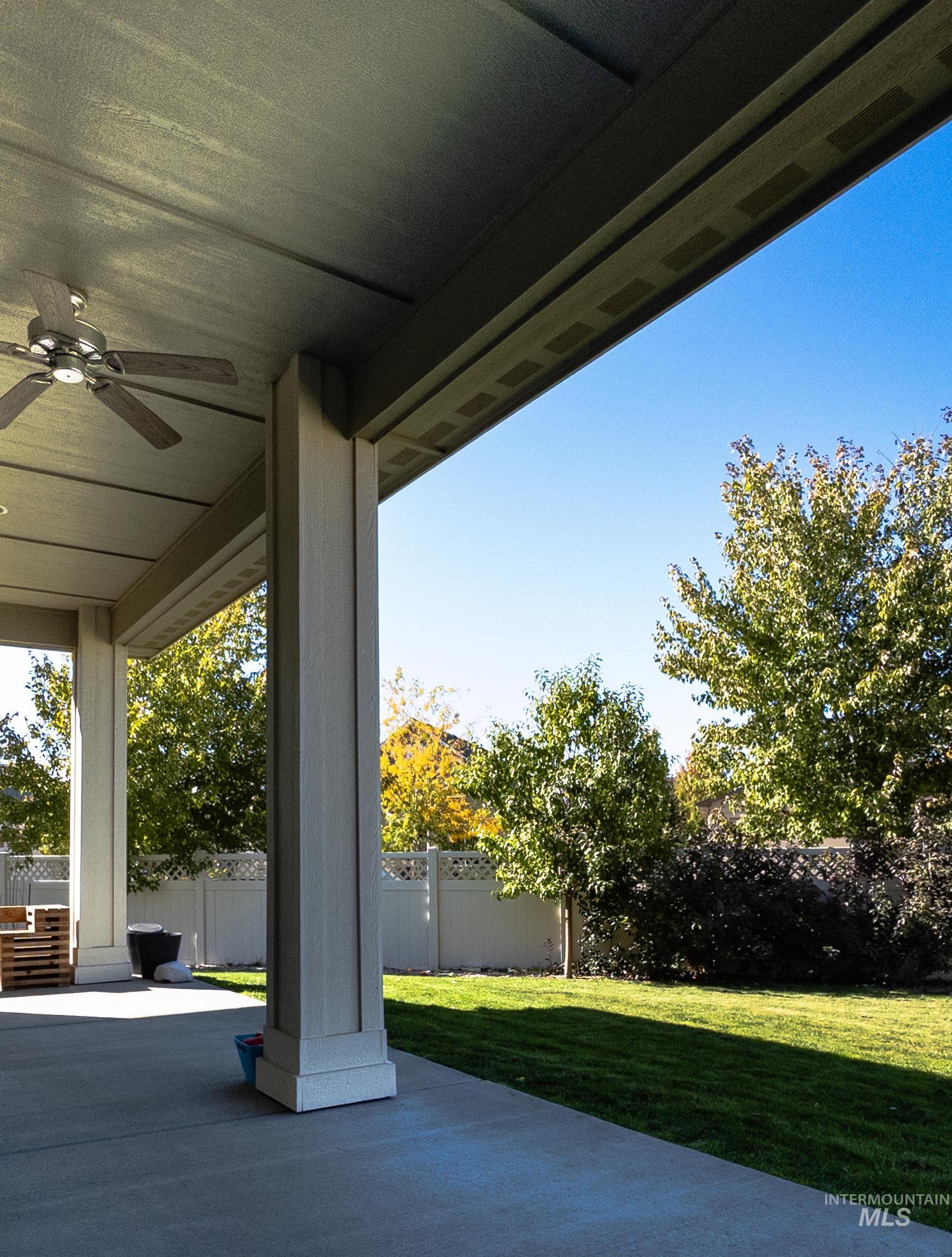 Fenced backyard featuring a ceiling fan and a patio area