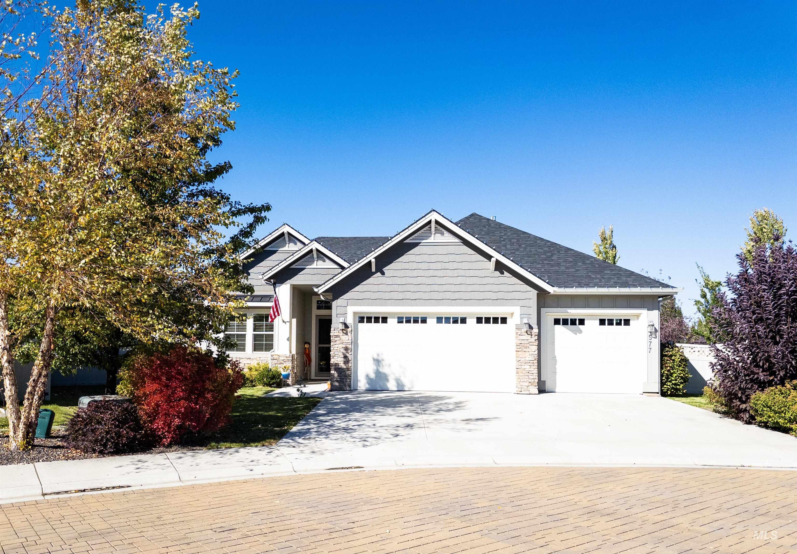 Craftsman house with concrete driveway, stone siding, and a garage