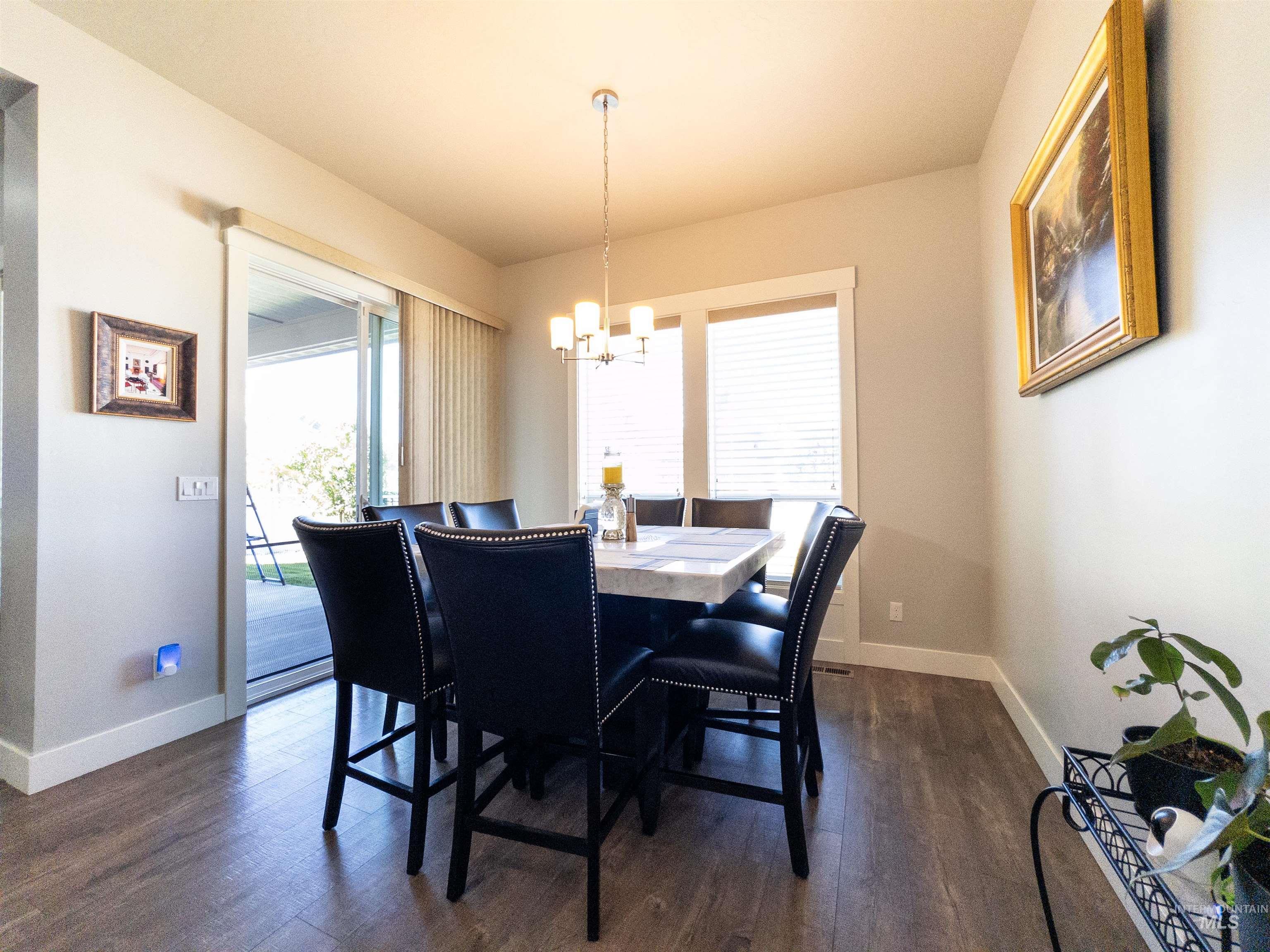 Dining room with dark wood-type flooring and a chandelier