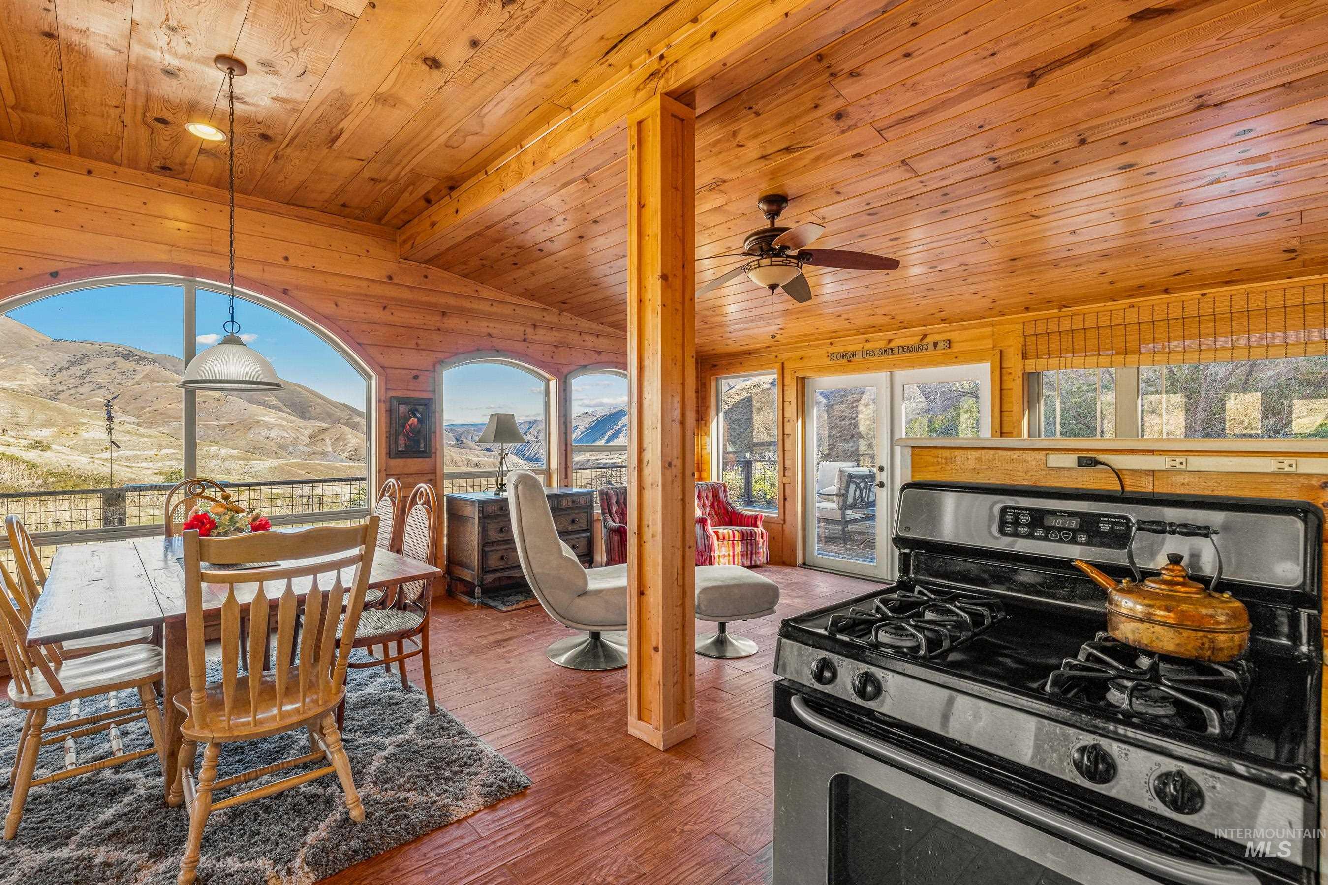 Dining area featuring a mountain view, hardwood / wood-style floors, lofted ceiling, wooden ceiling, and wood walls