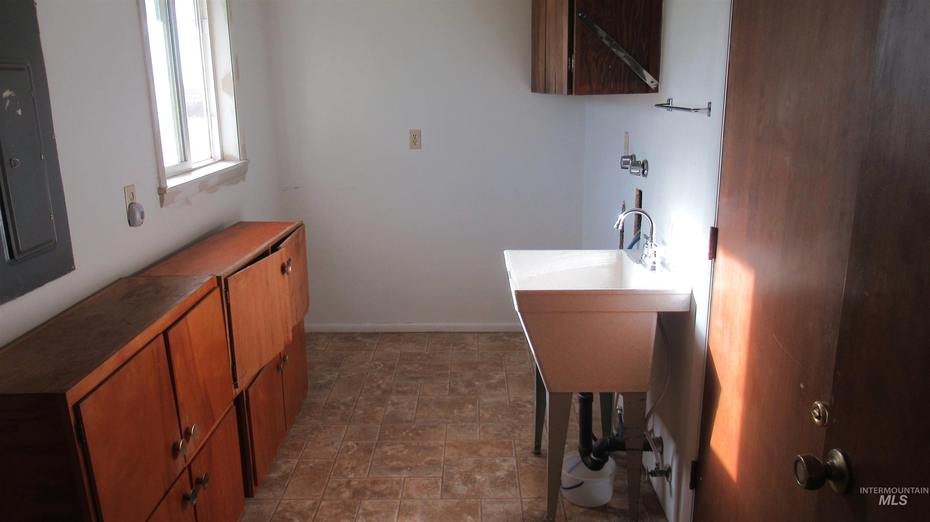 Bathroom featuring electric panel and baseboards