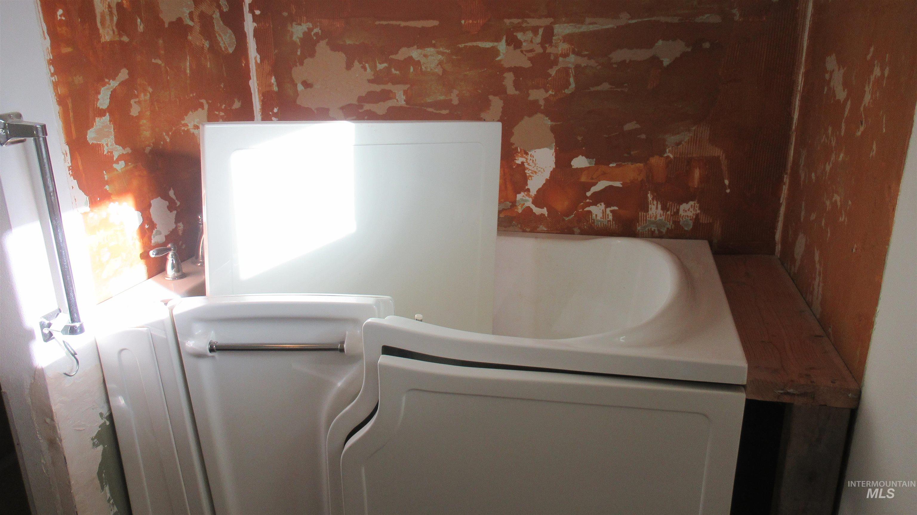 Bathroom view of wallpapered walls and a bath