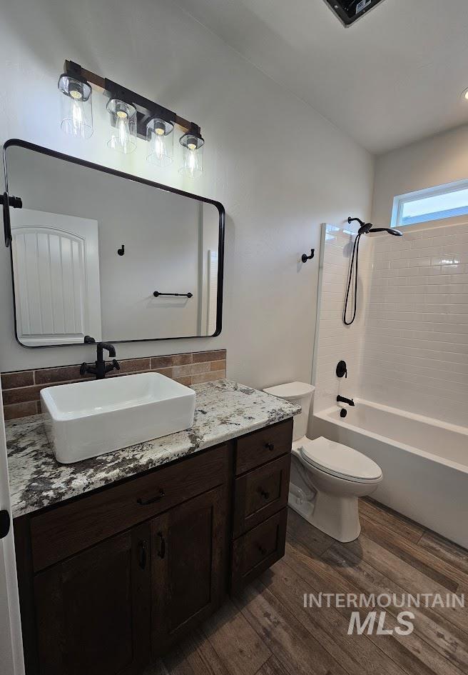 Full bathroom featuring tub / shower combination, dark wood-type flooring, and vanity