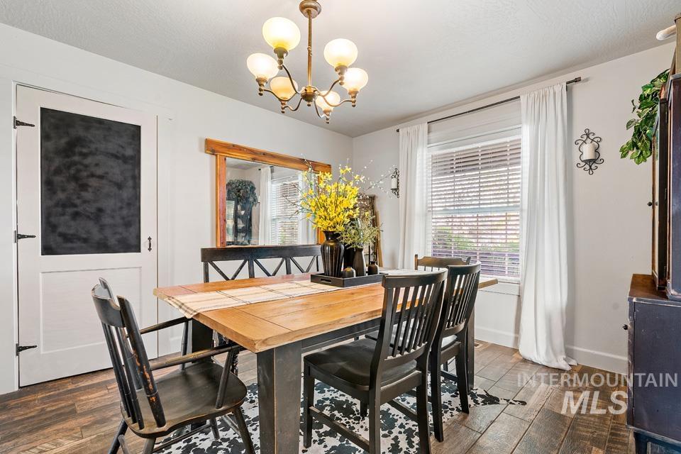 Dining room featuring dark wood finished floors and a chandelier