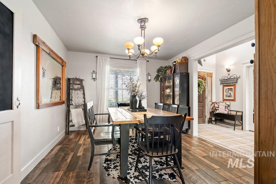 Dining space with dark wood-style flooring and a chandelier