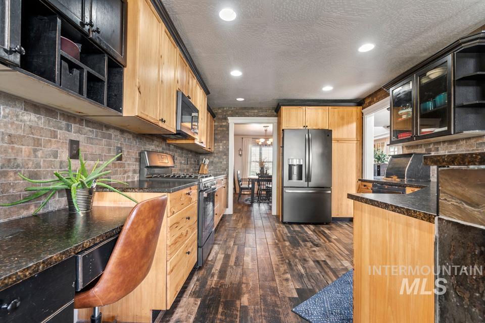 Kitchen featuring open shelves, glass insert cabinets, stainless steel appliances, dark wood finished floors, and backsplash