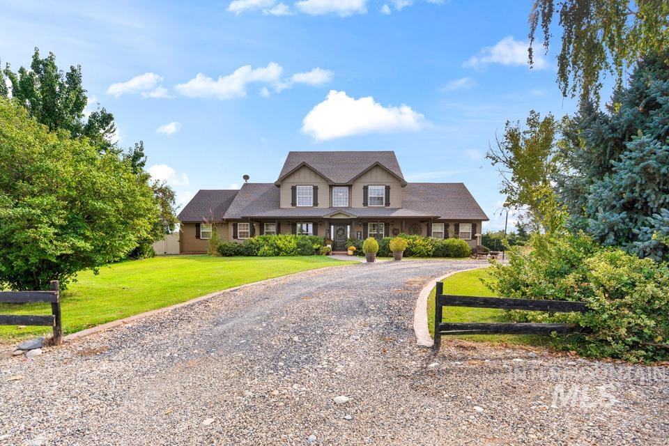 View of front of house featuring gravel driveway, a porch, and a front lawn