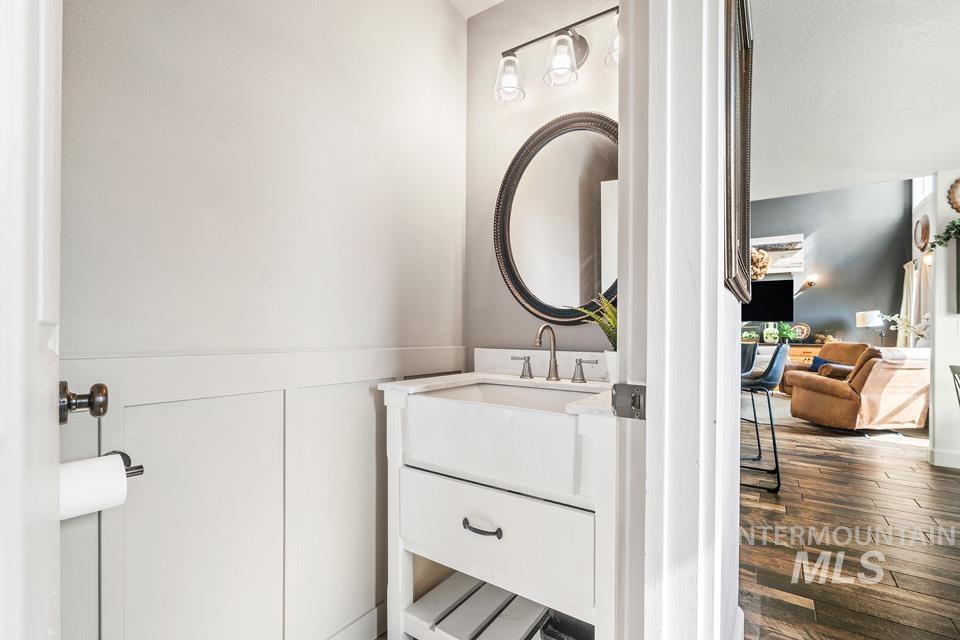 Half bathroom featuring vanity and dark wood-style flooring