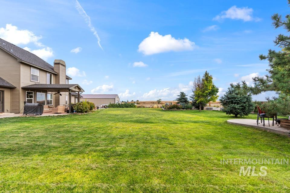 View of grassy yard featuring a patio area