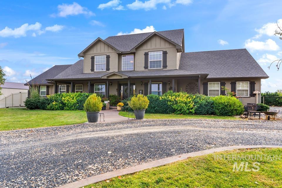 Craftsman inspired home featuring board and batten siding, a shingled roof, and covered porch