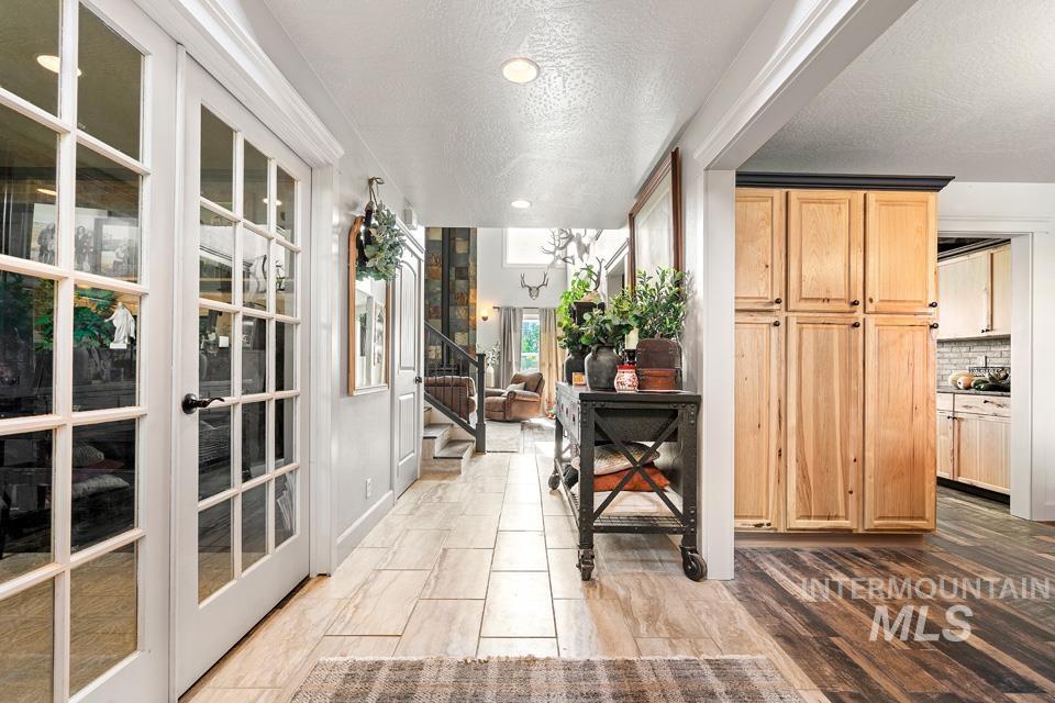 Corridor with stairs, a textured ceiling, and recessed lighting
