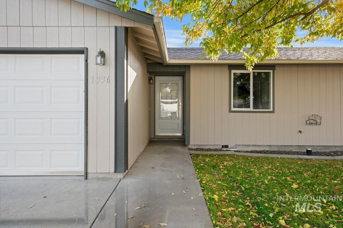 Entrance to property with a shingled roof, an attached garage, and crawl space