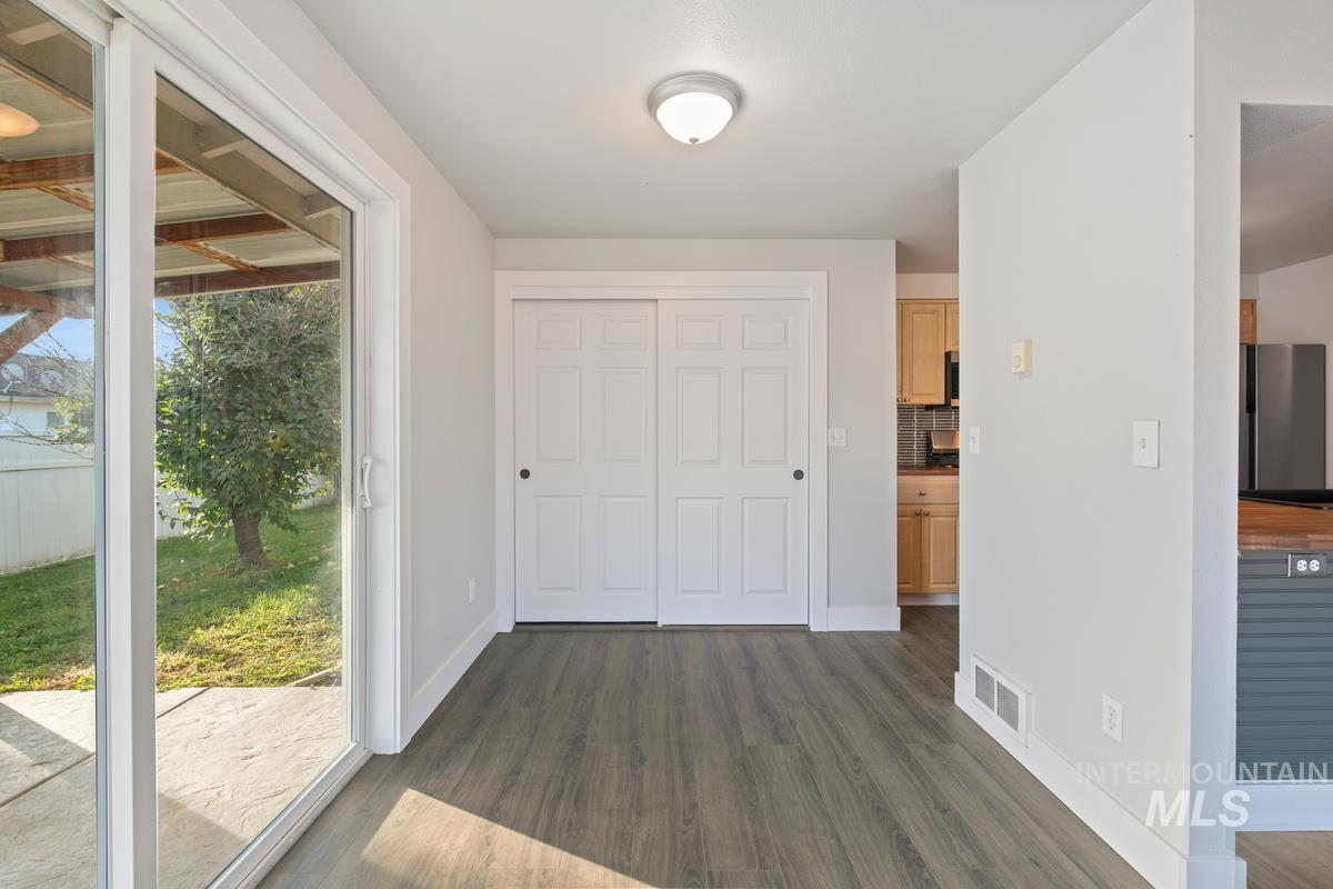 Foyer with dark wood-style flooring and baseboards
