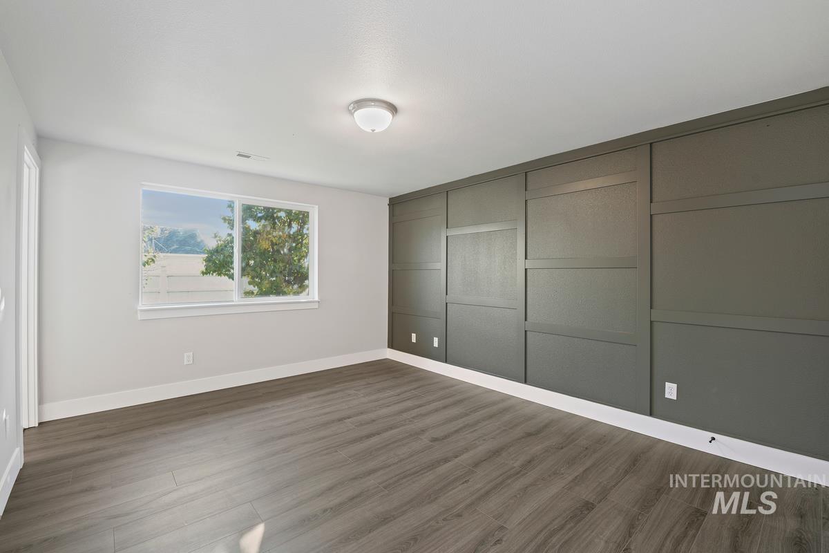 Unfurnished bedroom featuring wood finished floors and a closet