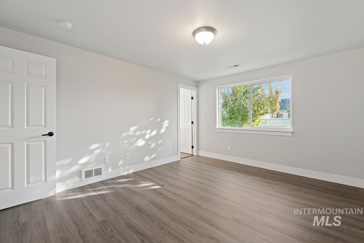 Unfurnished room featuring wood finished floors and baseboards