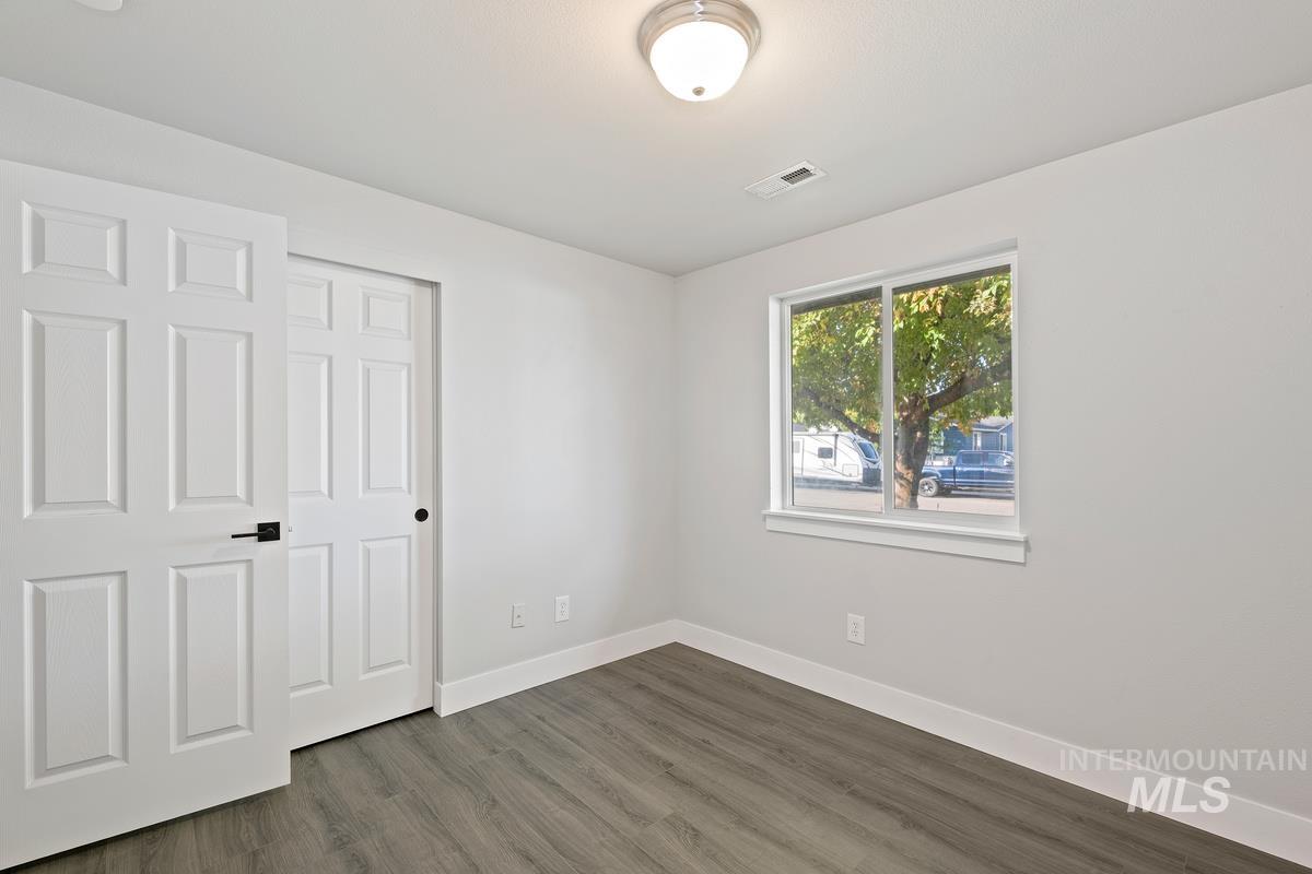 Unfurnished bedroom featuring wood finished floors and a closet