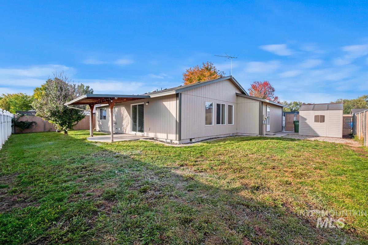 Rear view of house with a patio area, a fenced backyard, a storage shed, and crawl space