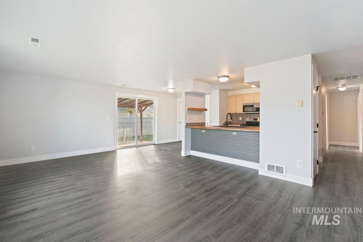 Unfurnished living room with dark wood finished floors