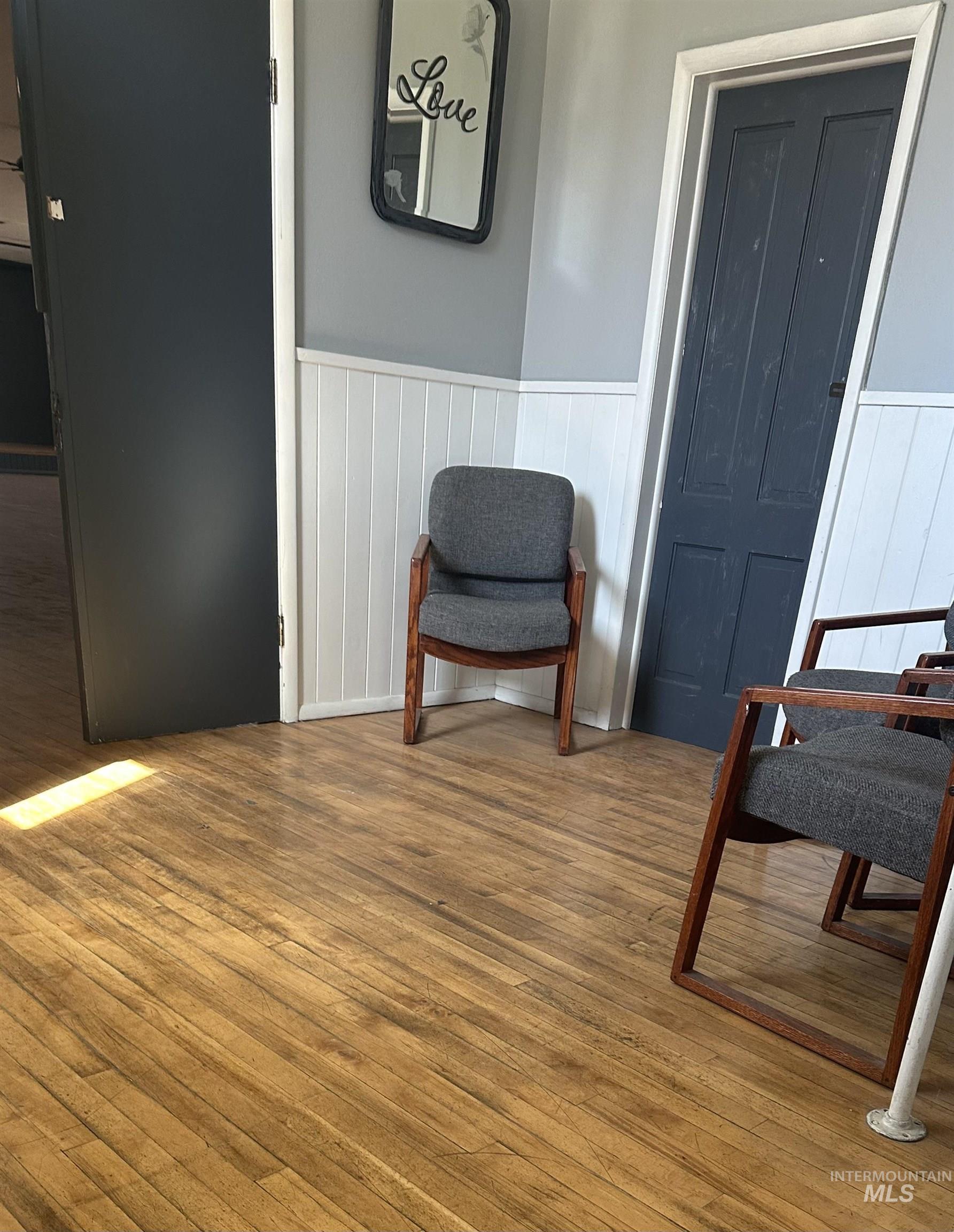 Sitting room with wood finished floors and wainscoting