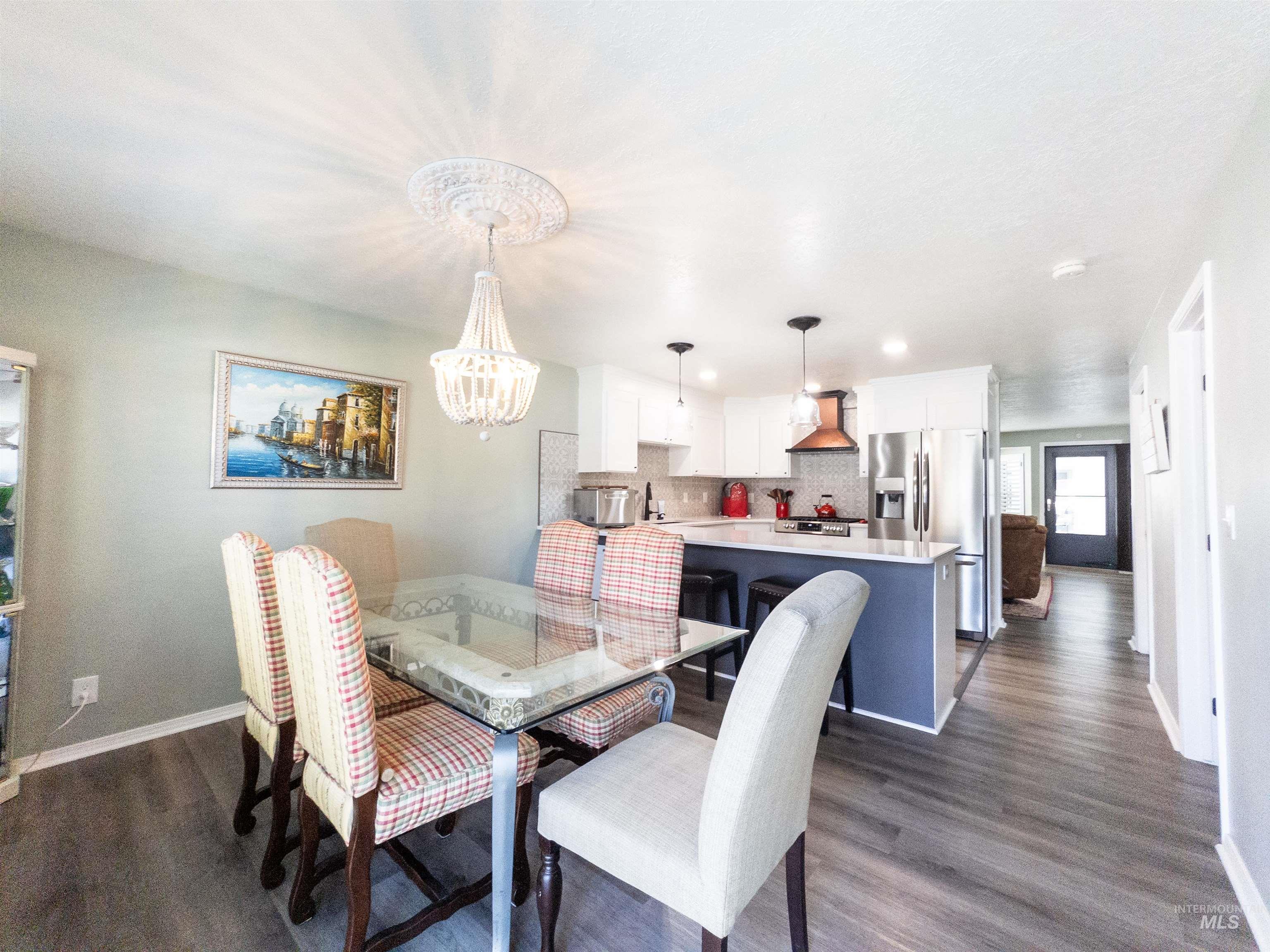 Dining space featuring dark wood-style flooring and a chandelier