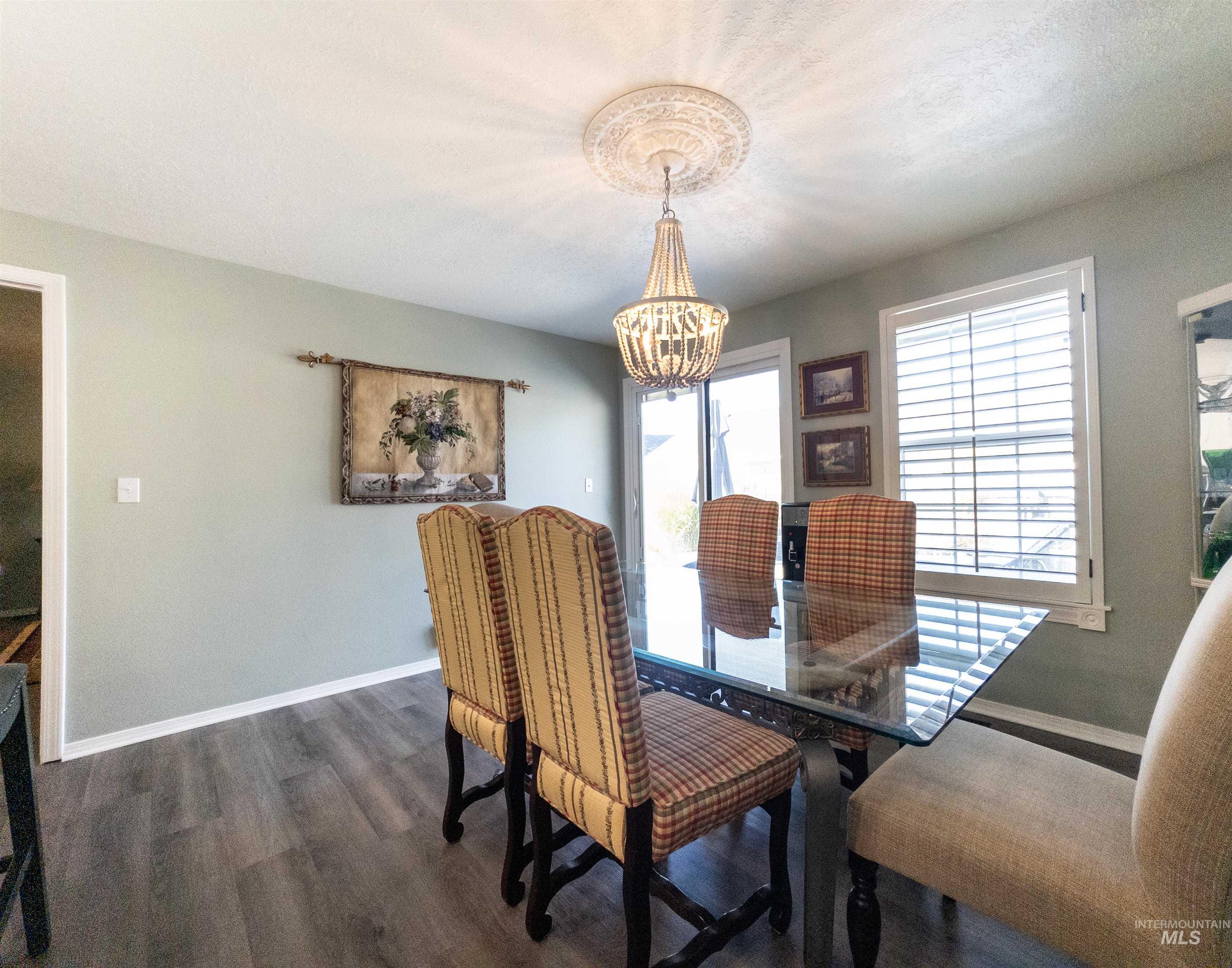 Dining space with wood finished floors and a chandelier