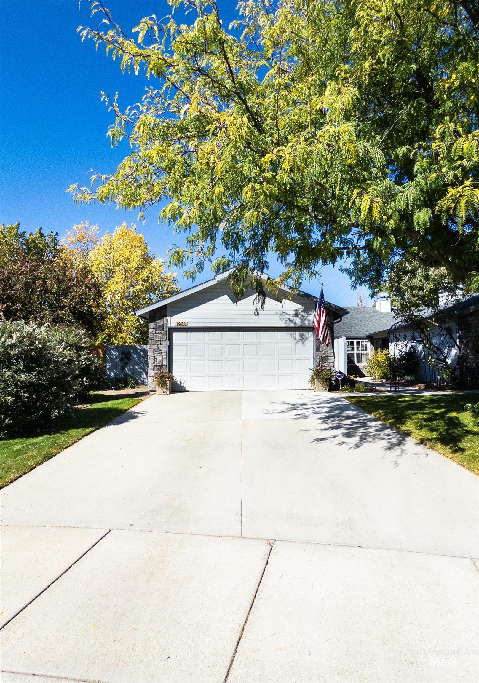 Single story home featuring concrete driveway, a garage, and stone siding