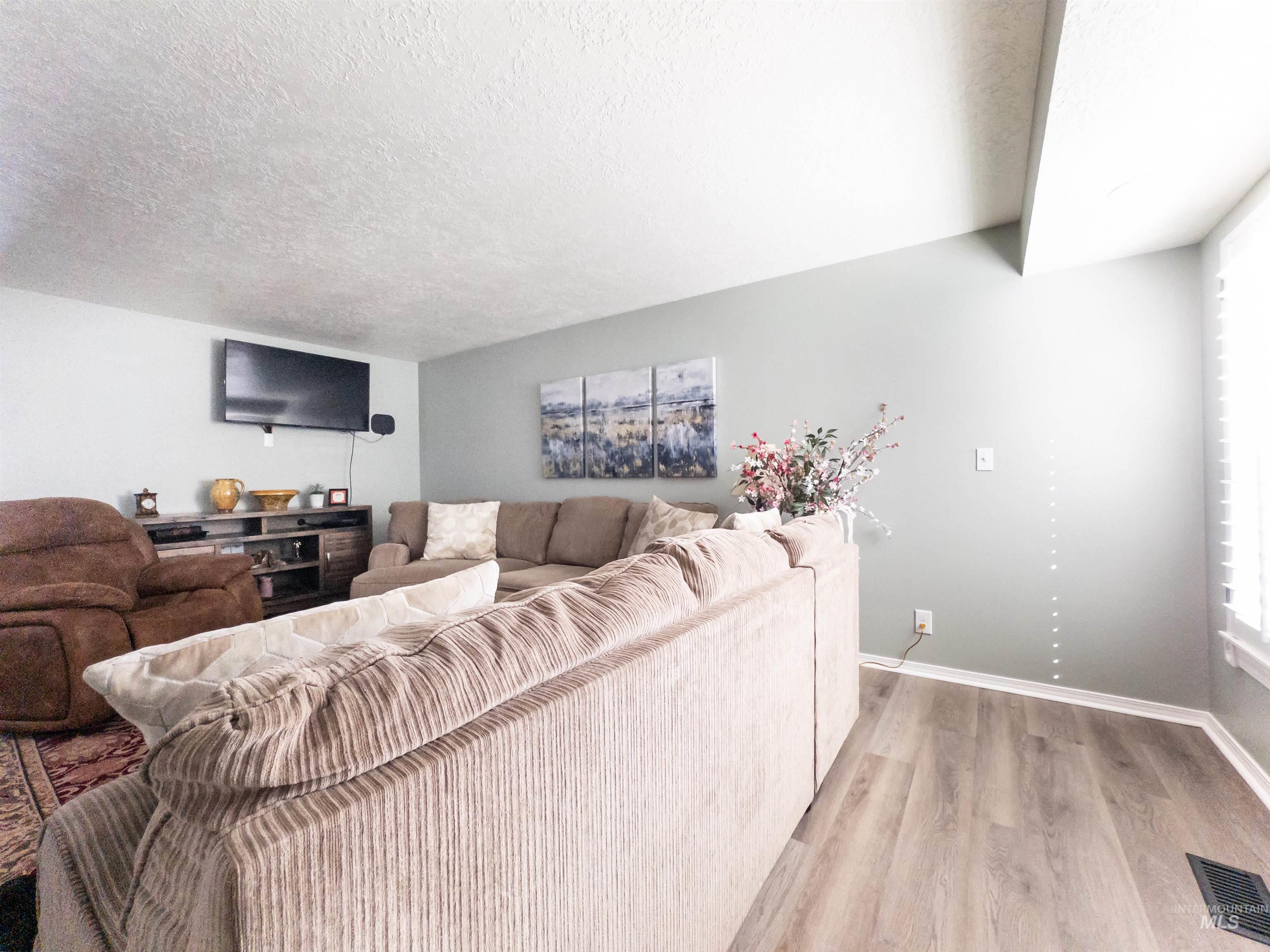 Living area with a textured ceiling and light wood finished floors