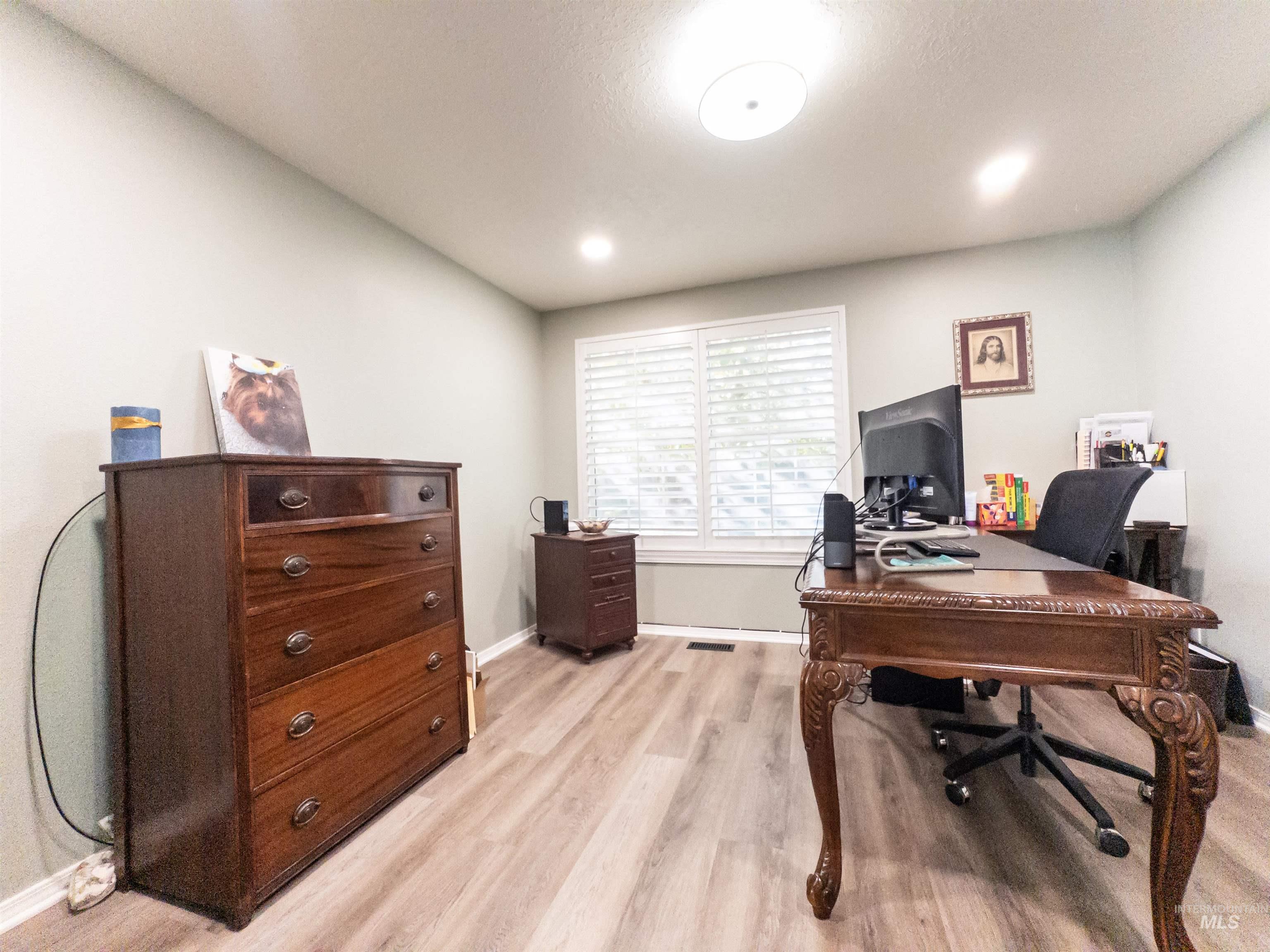 Office space with light wood-style floors and recessed lighting