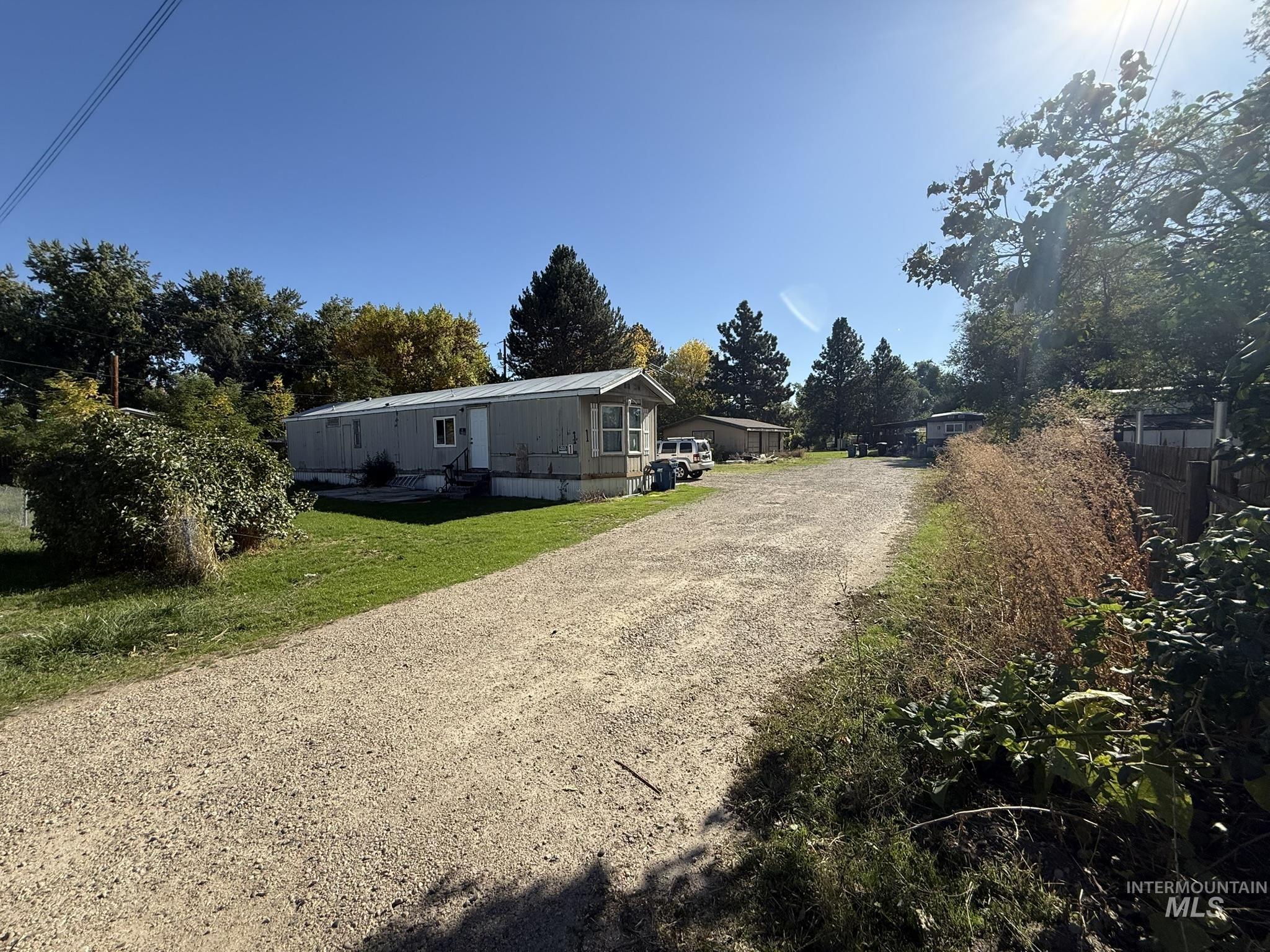 View of side of property with driveway and a yard