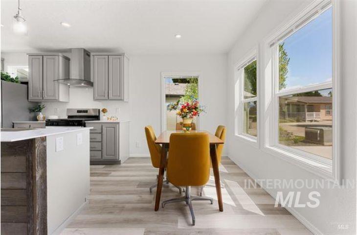 Kitchen featuring gray cabinetry, wall chimney range hood, stainless steel electric range, recessed lighting, and light wood finished floors