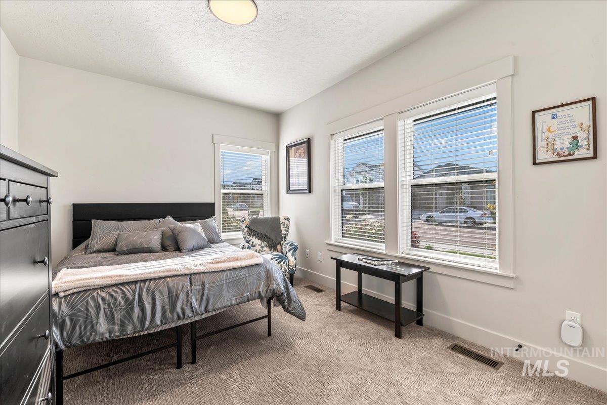 Bedroom with light carpet and a textured ceiling