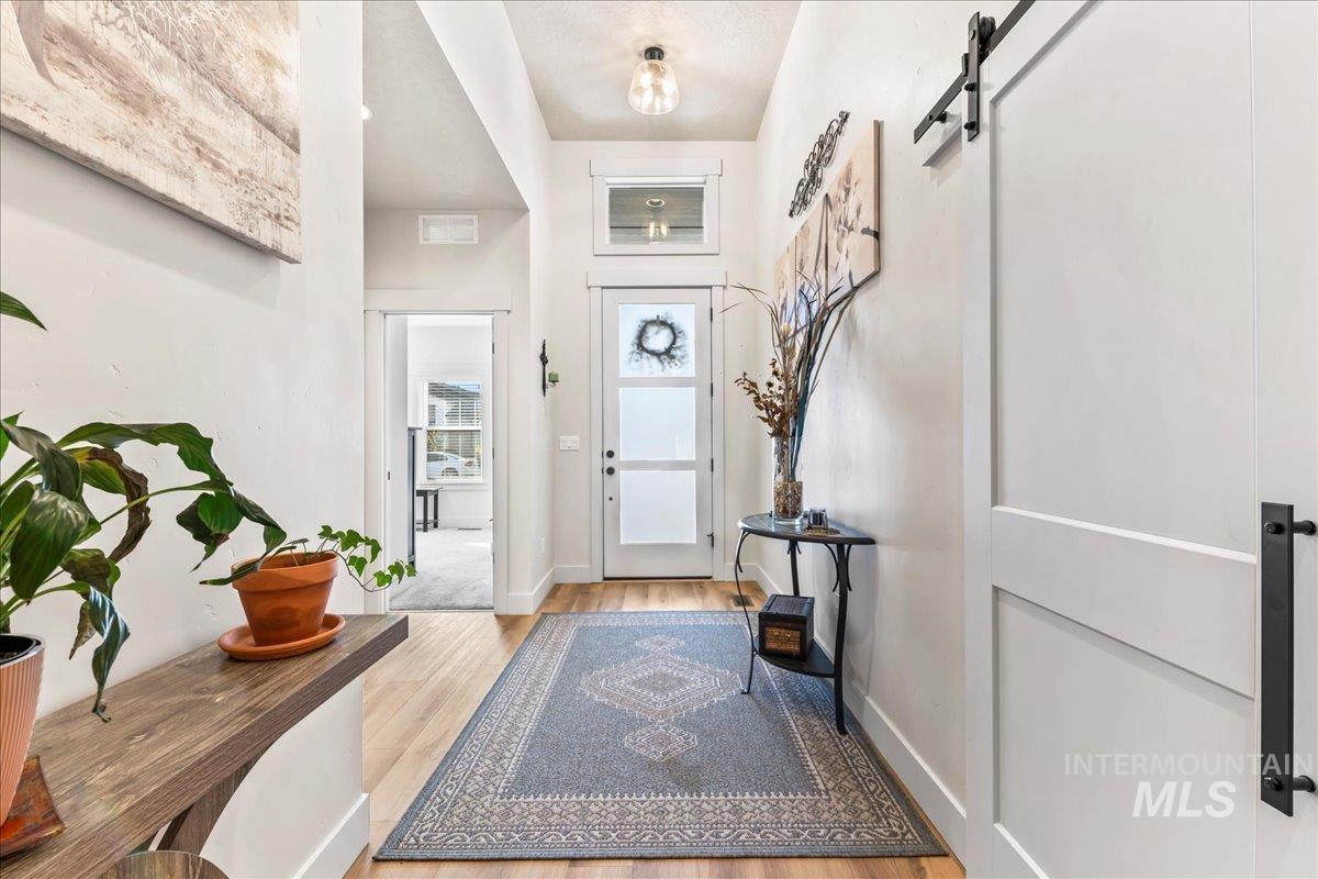 Entrance foyer featuring a barn door and light wood-style flooring