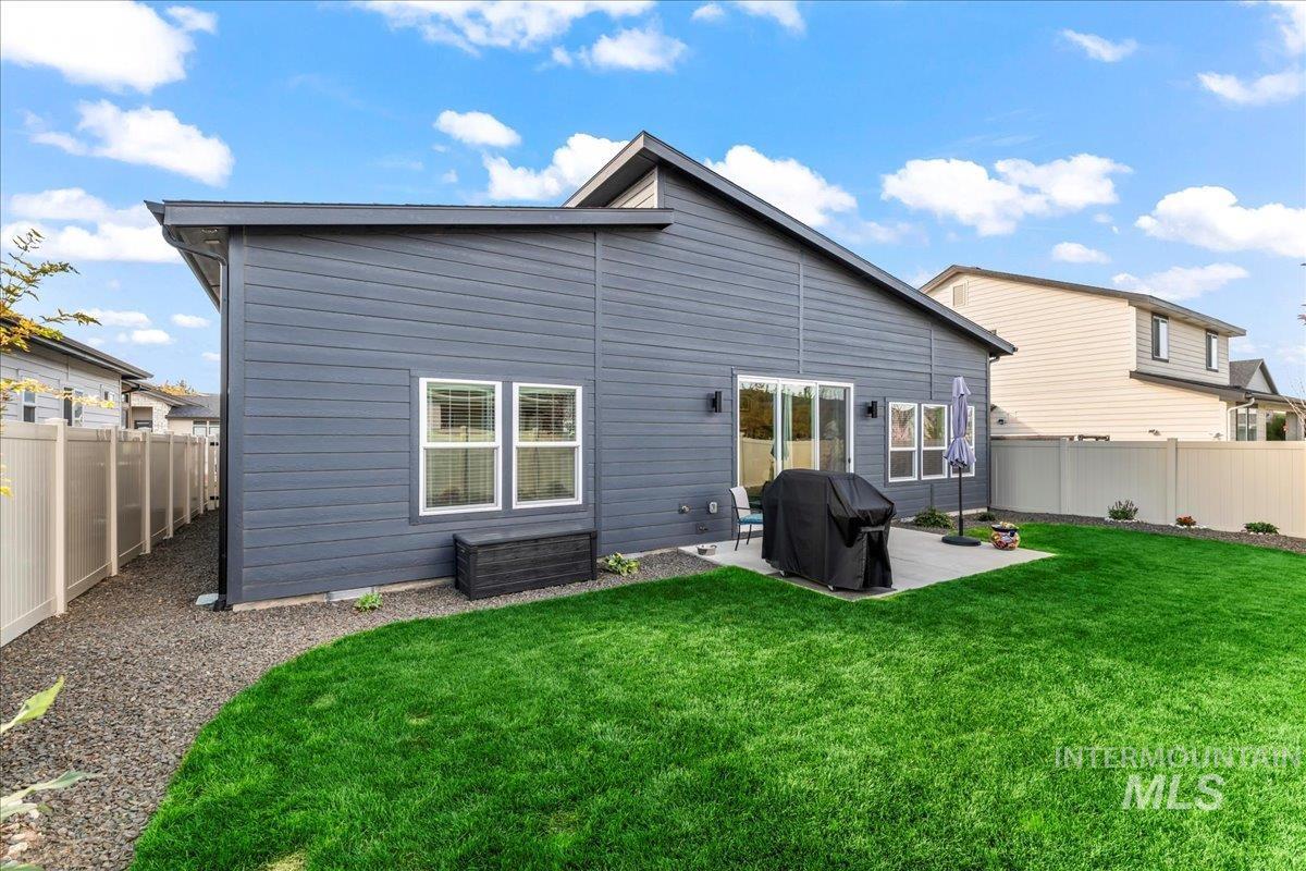 Rear view of property featuring a fenced backyard and a patio