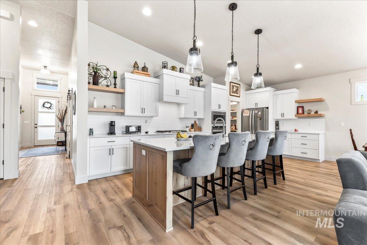 Kitchen featuring open shelves, white cabinetry, and recessed lighting