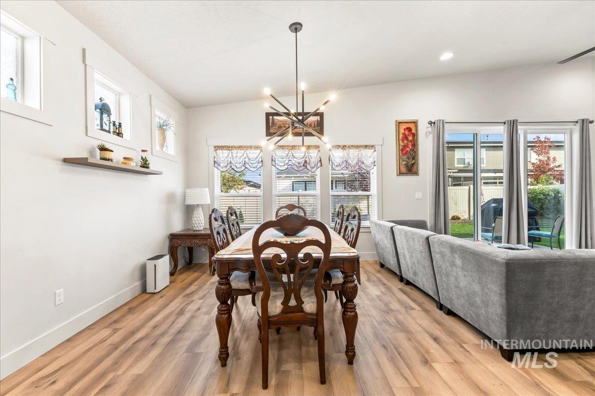 Dining area featuring light wood-type flooring, a chandelier, and recessed lighting