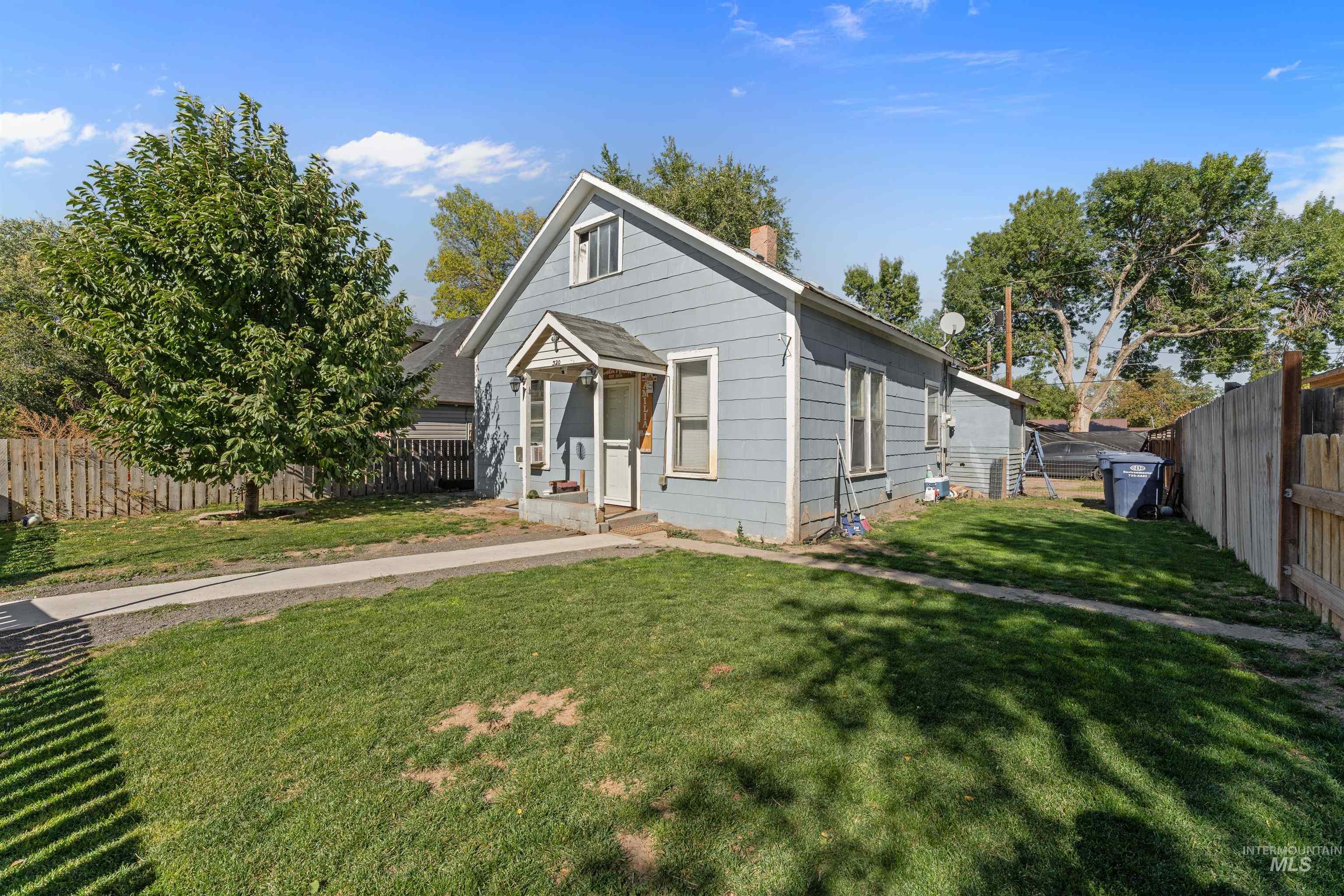 View of front facade featuring a fenced backyard and a chimney