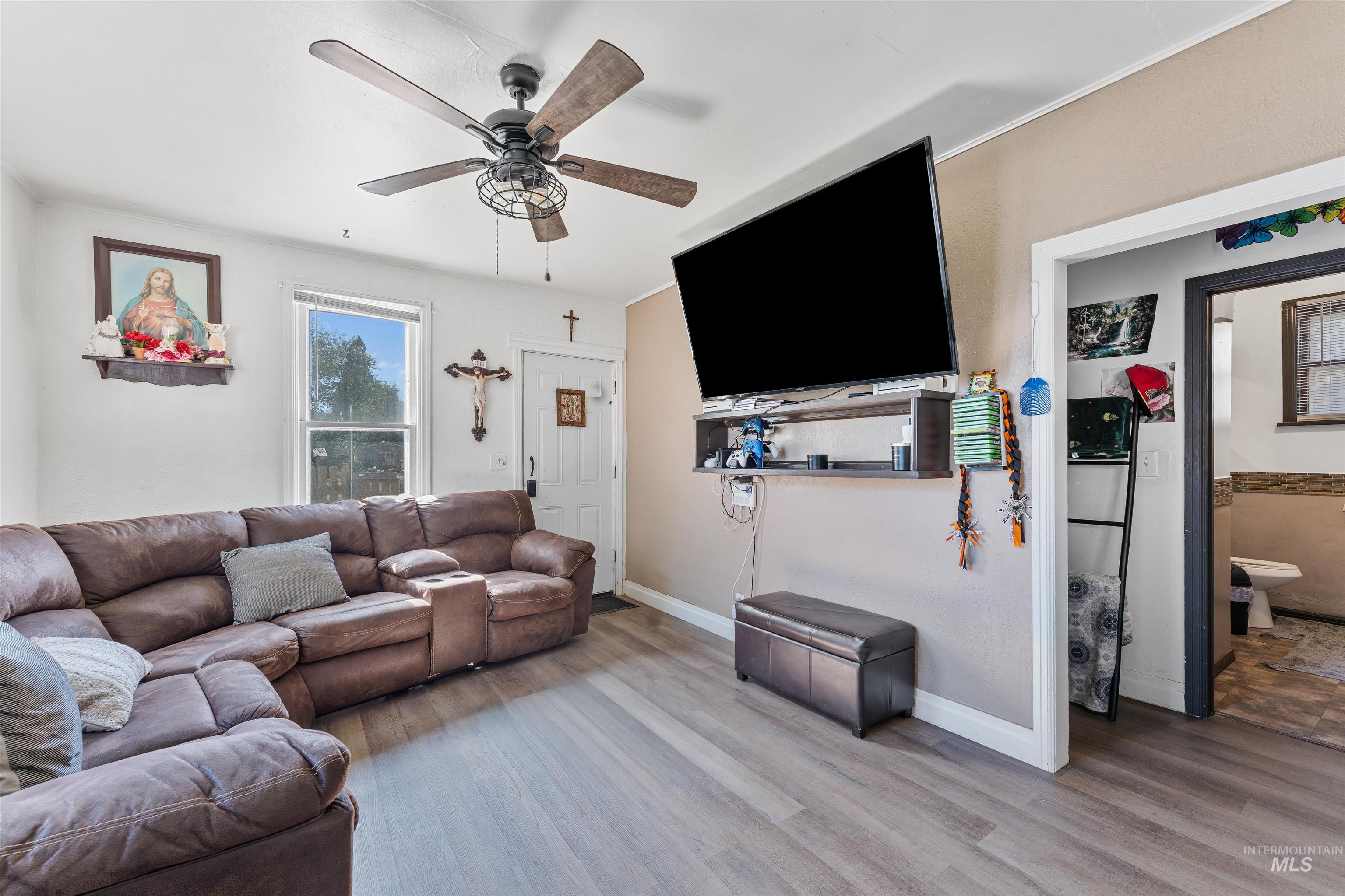 Living room with wood finished floors and a ceiling fan