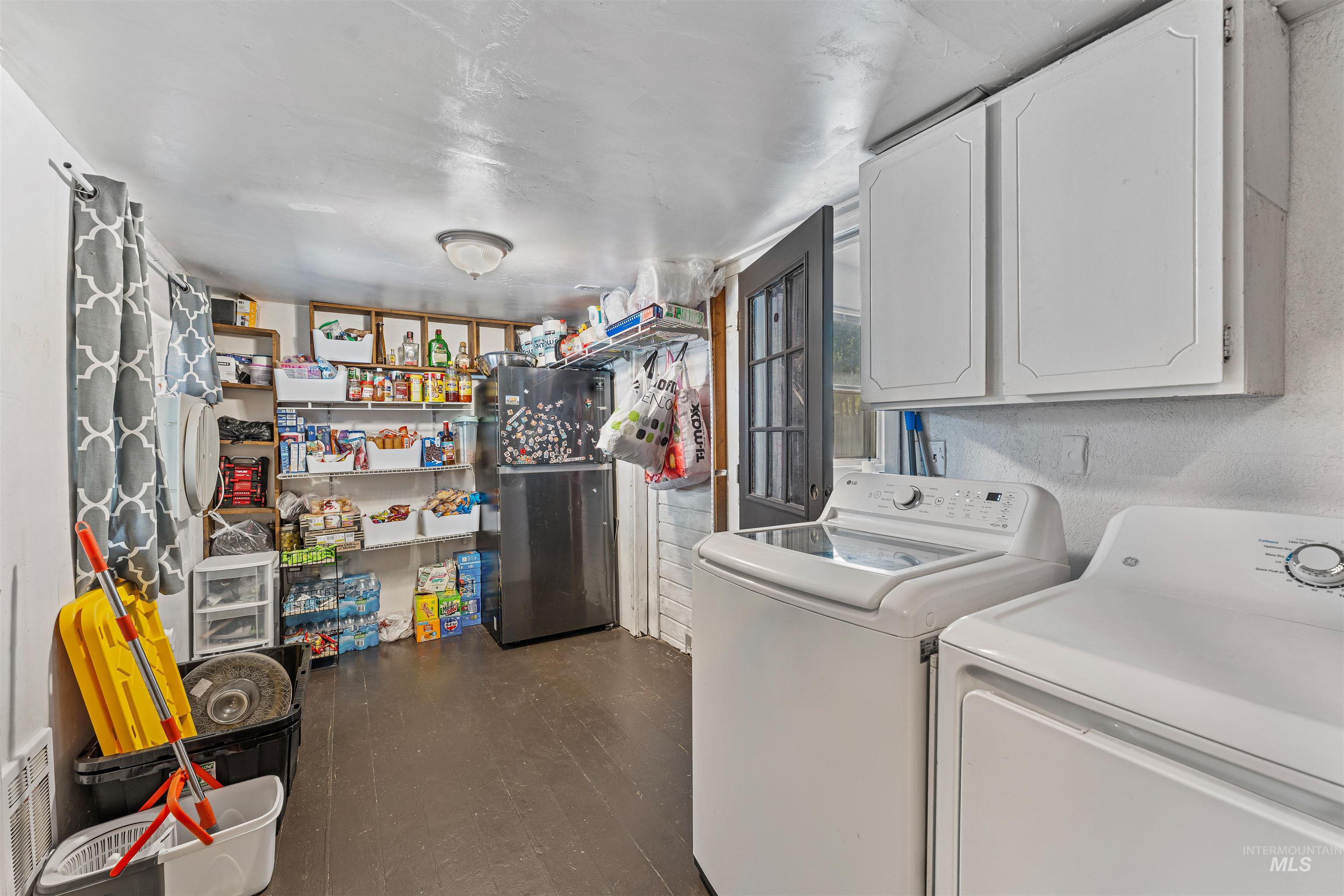 Washroom featuring dark wood finished floors and washer and clothes dryer