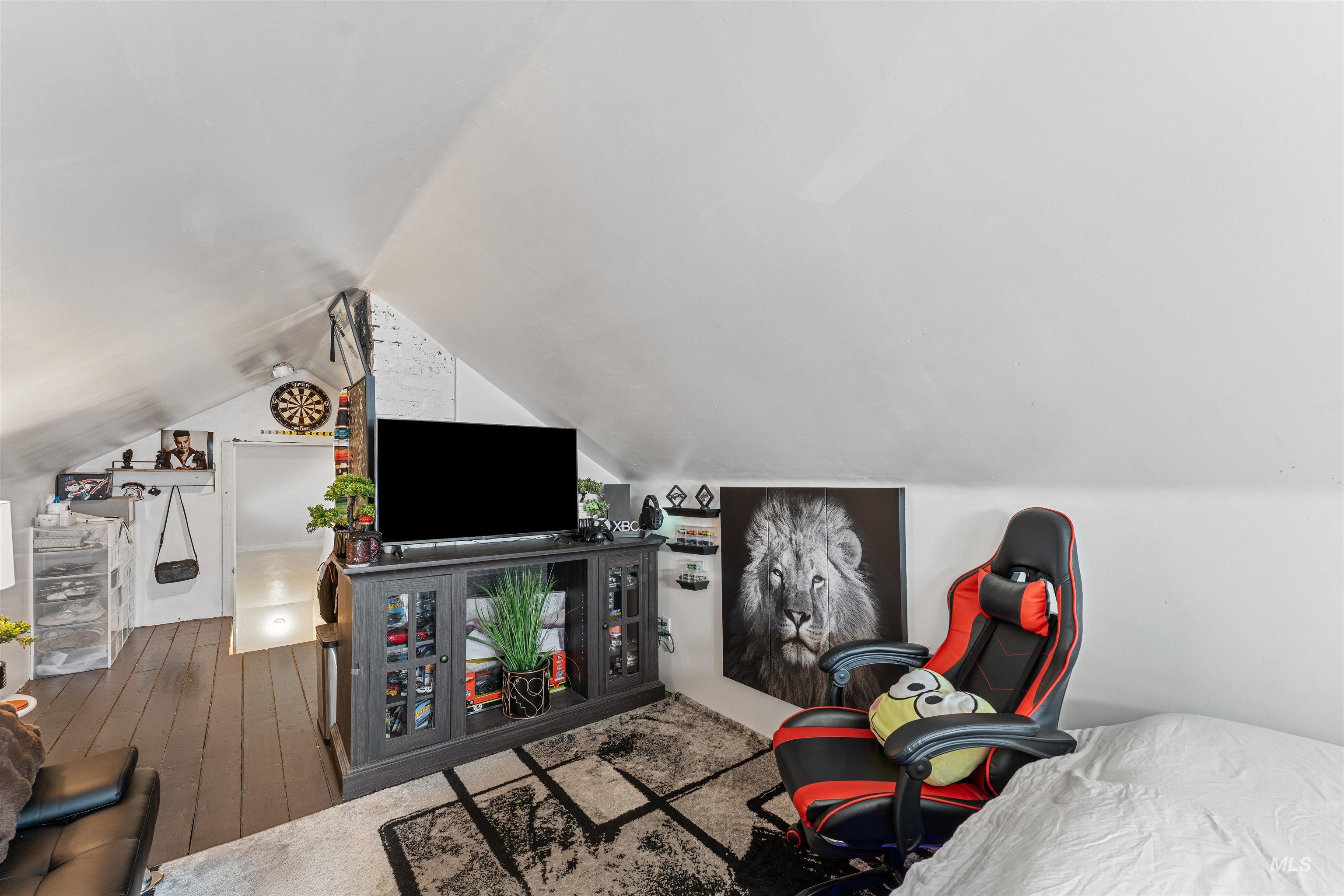 Living area with hardwood / wood-style floors and lofted ceiling