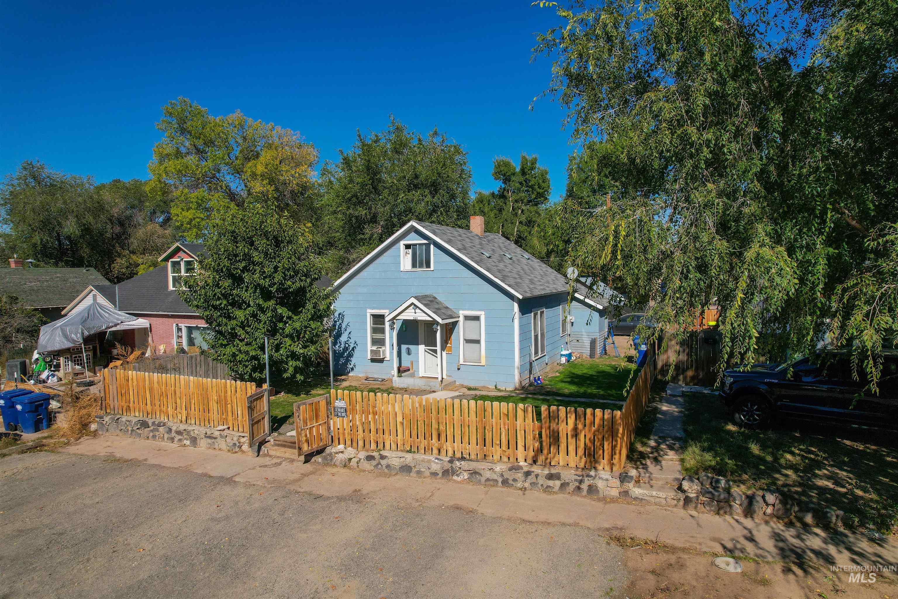 Bungalow-style house featuring a fenced front yard and a chimney