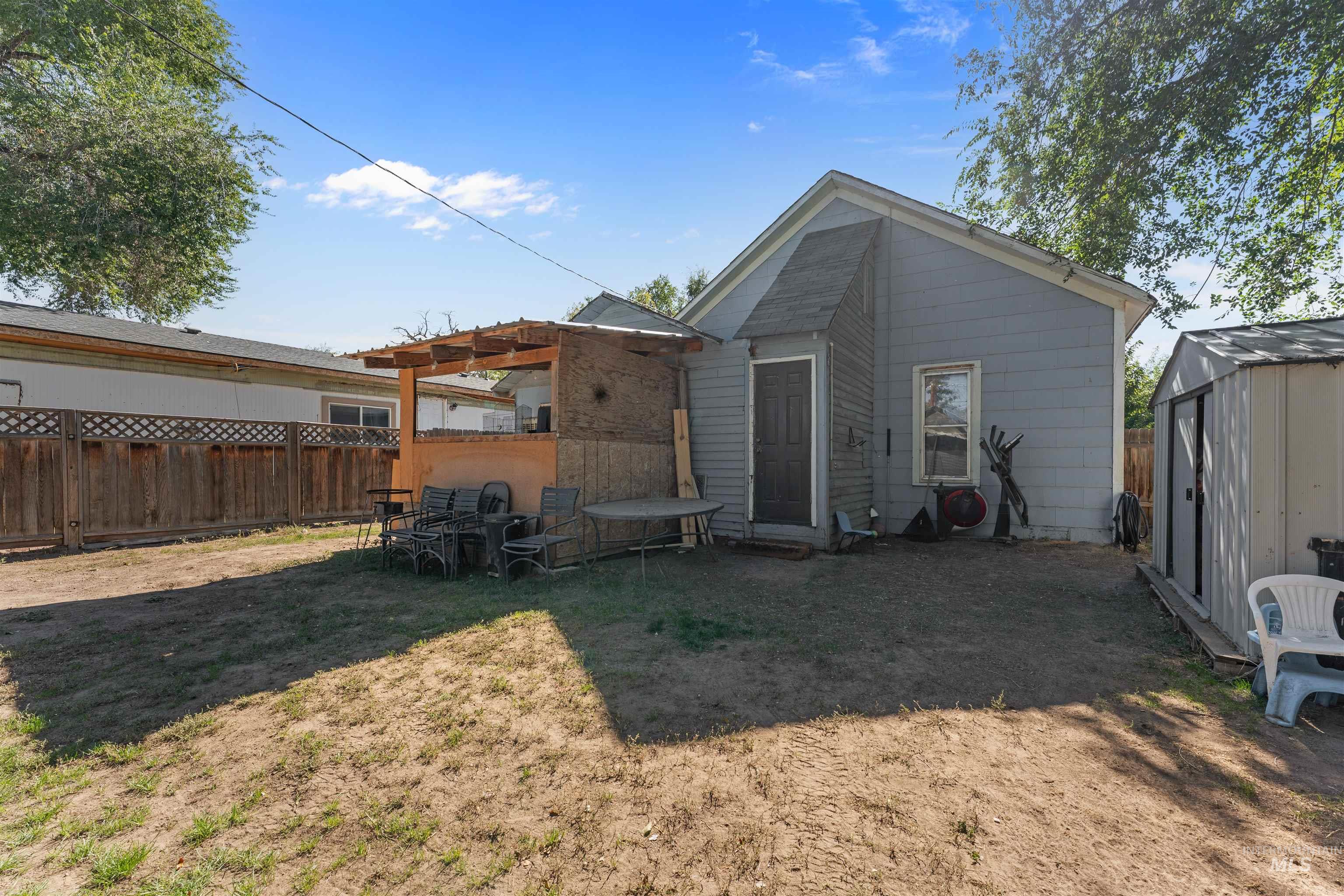 Rear view of house with a shed and a patio area