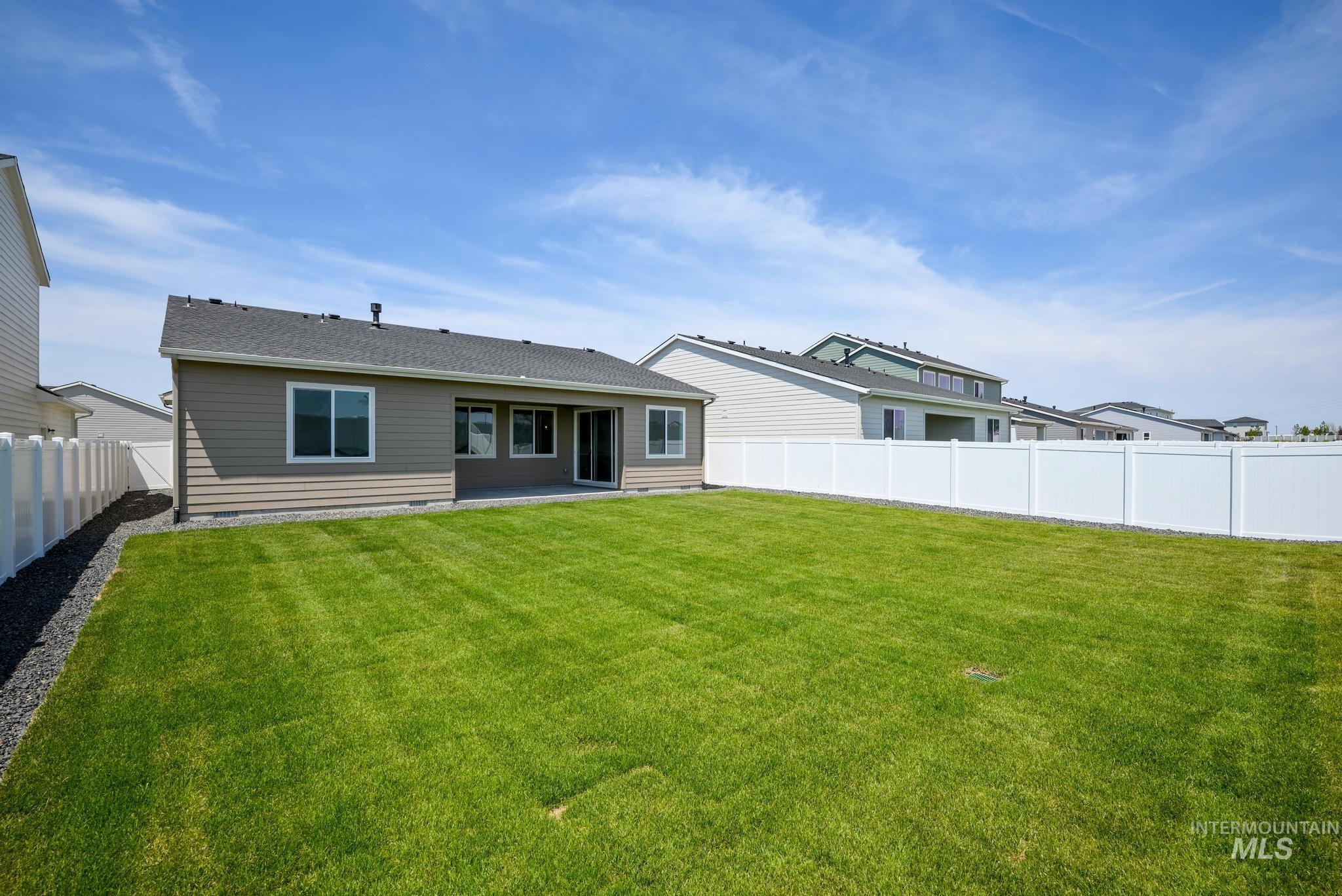Rear view of house with a patio area, a fenced backyard, and a shingled roof