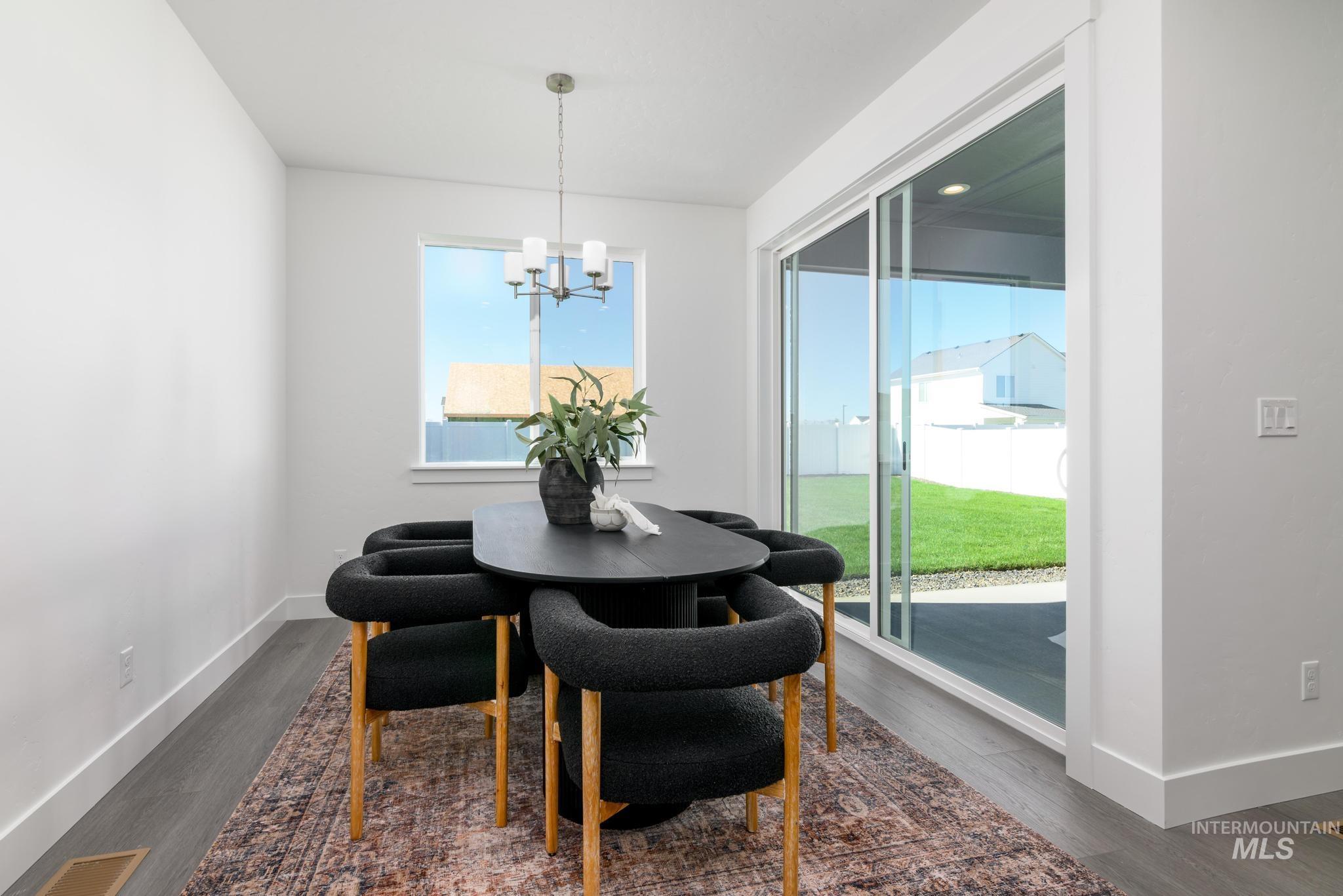 Dining space featuring dark wood-style floors and a chandelier