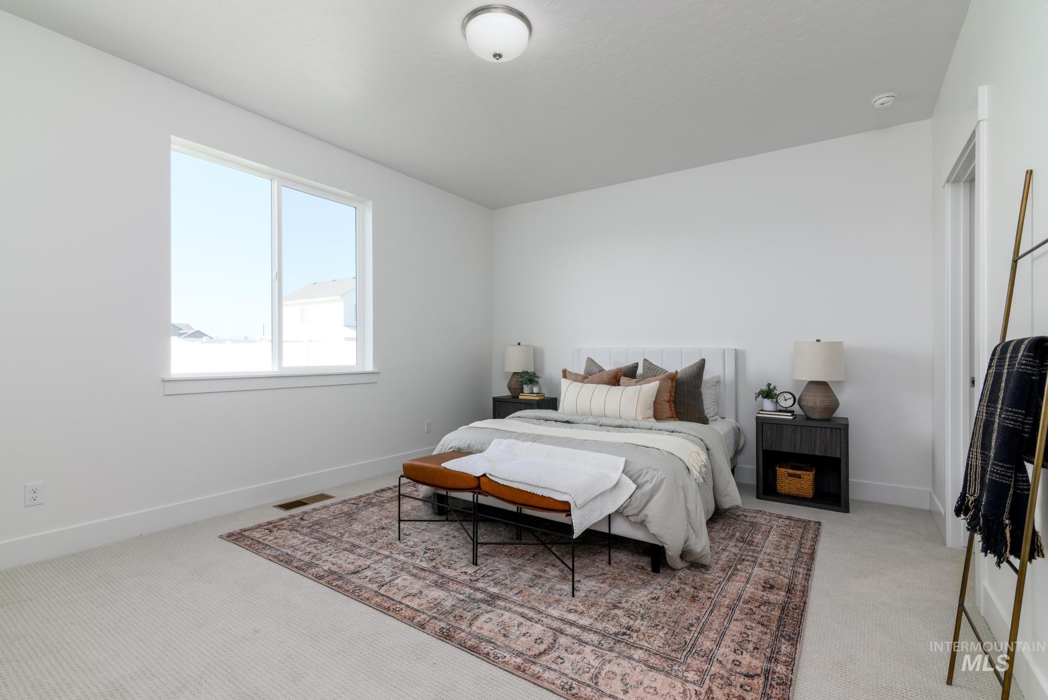 Bedroom featuring light carpet and baseboards
