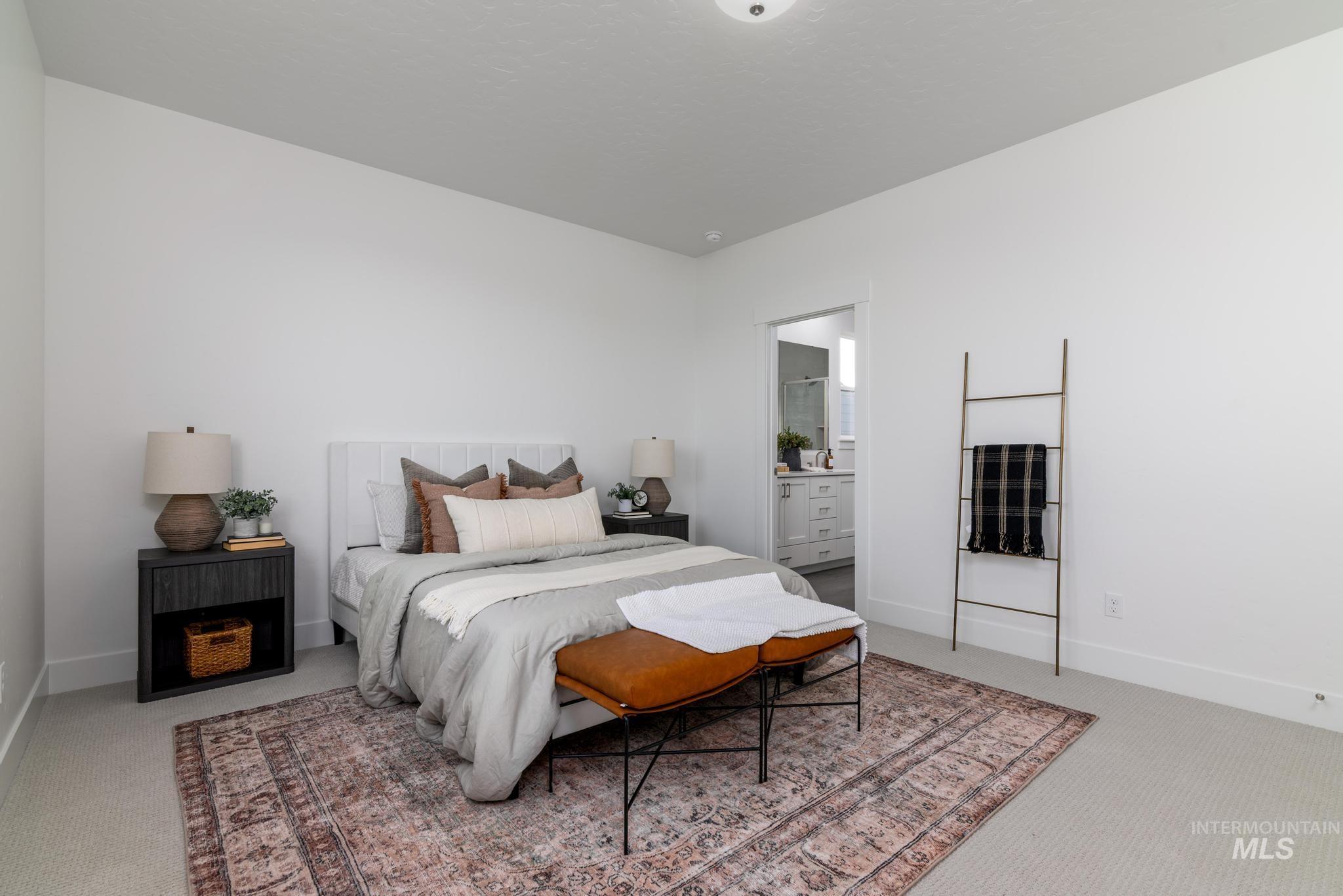 Carpeted bedroom with baseboards and connected bathroom