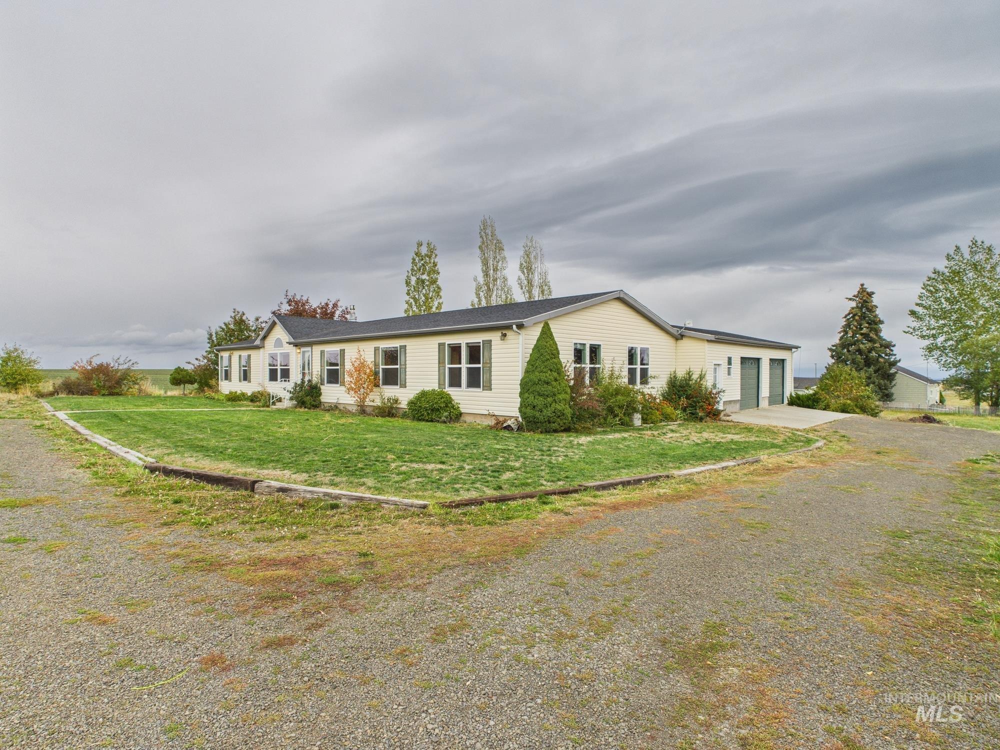 Single story home with gravel driveway and a front lawn