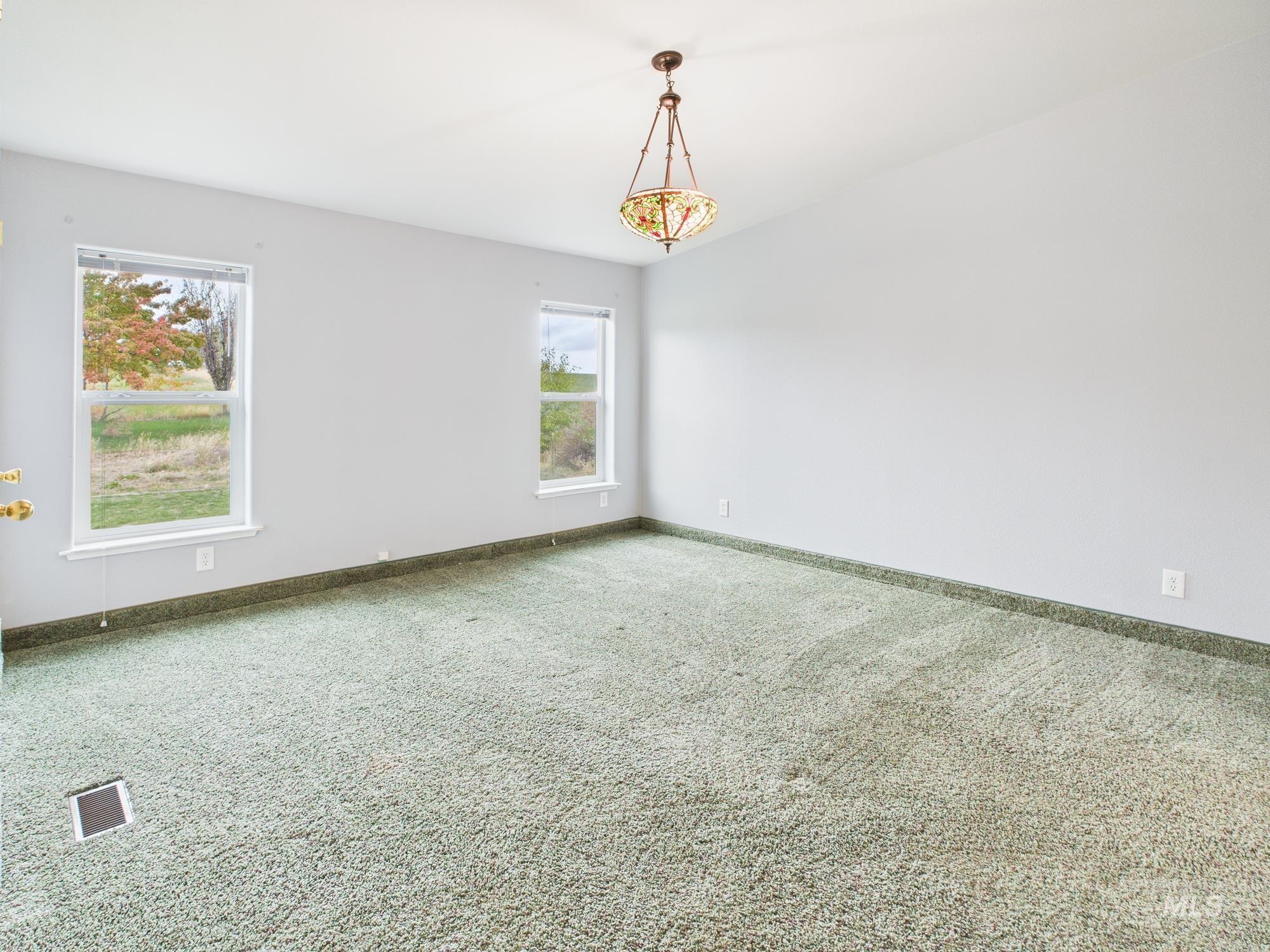 Carpeted empty room featuring baseboards