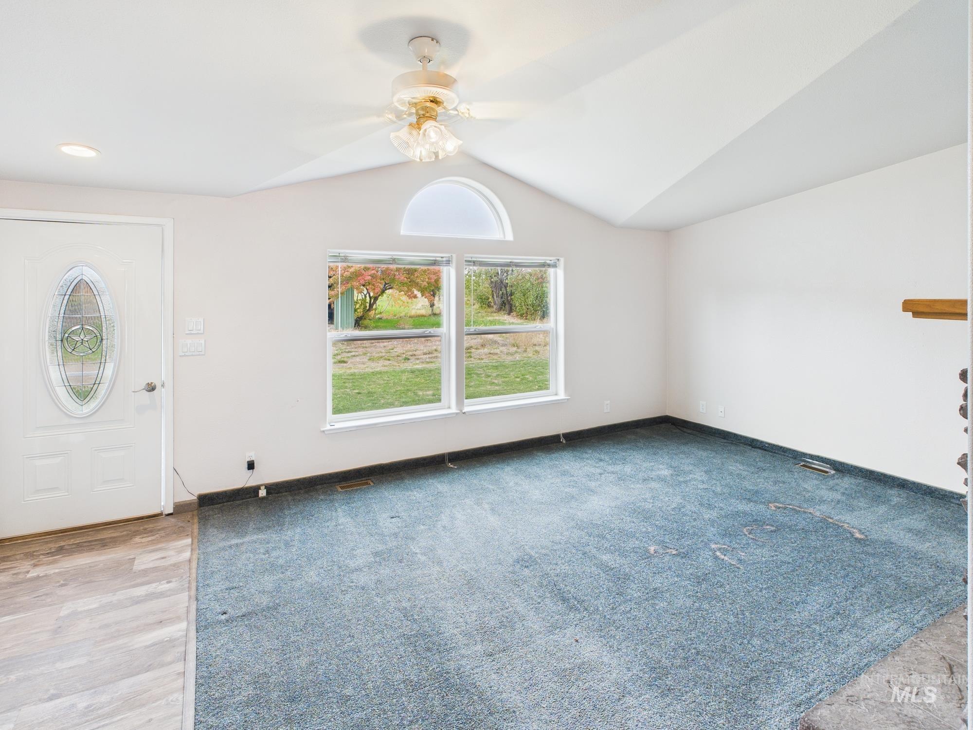 Entrance foyer featuring vaulted ceiling, ceiling fan, and light wood finished floors
