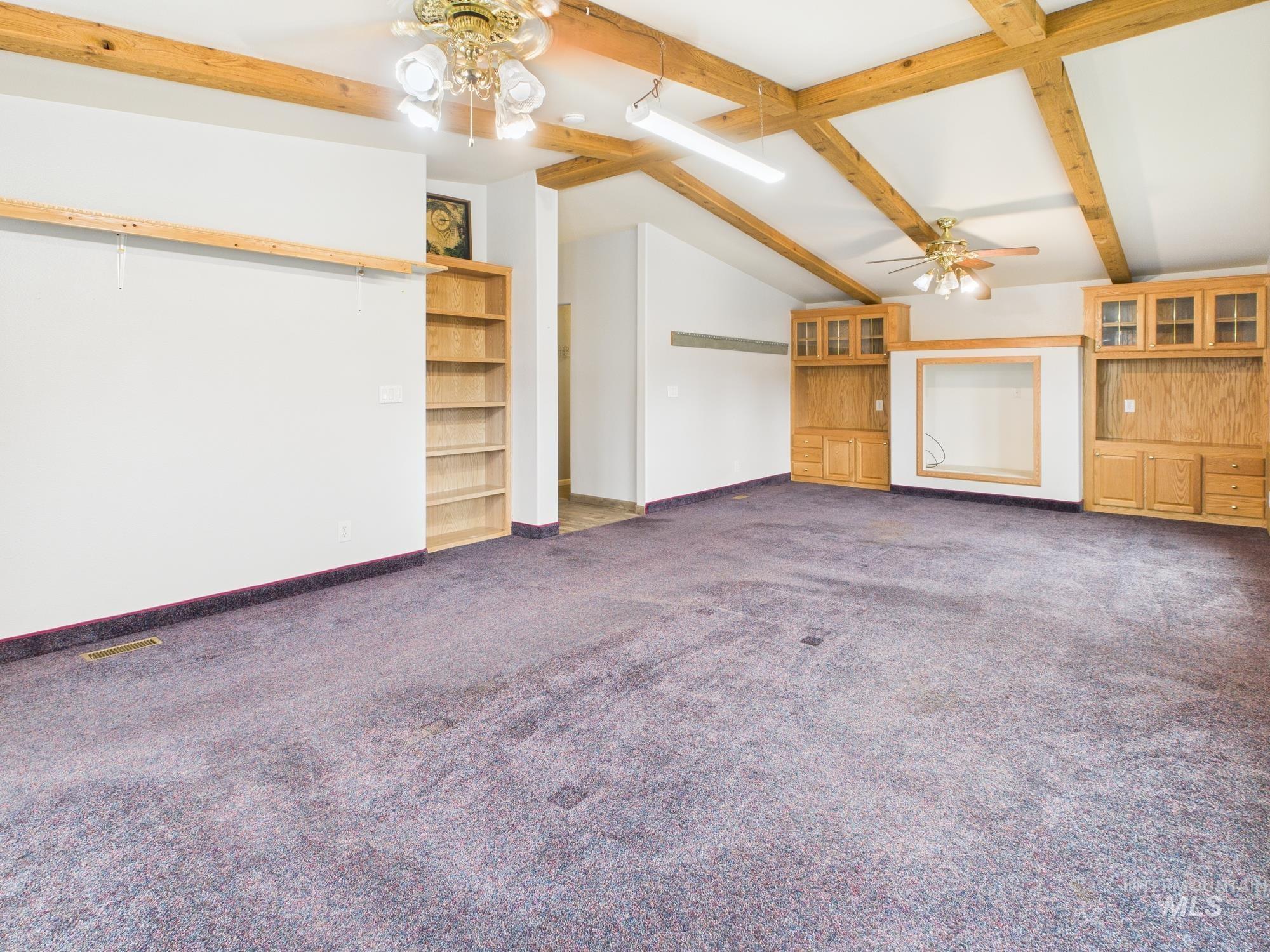 large den with beautiful custom built in shelving.