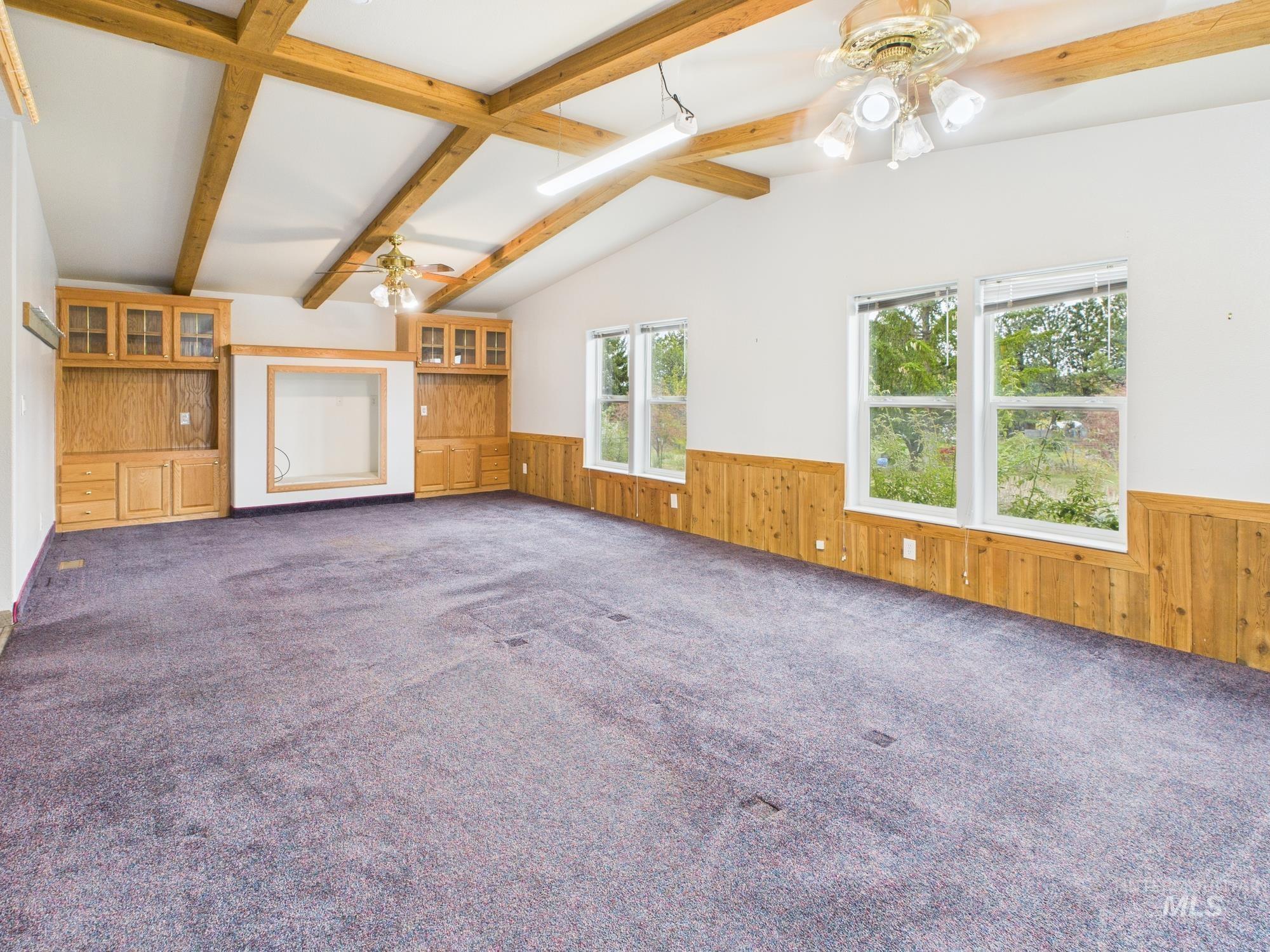 wainscoting, ceiling fan, and dark carpet